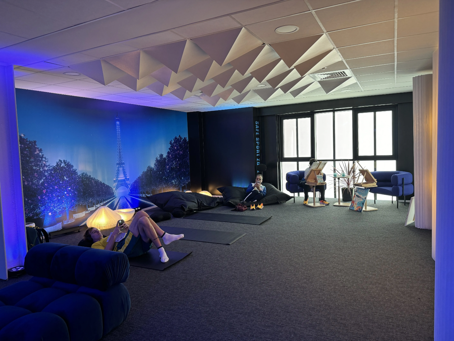 People lounge in a large white and purple room