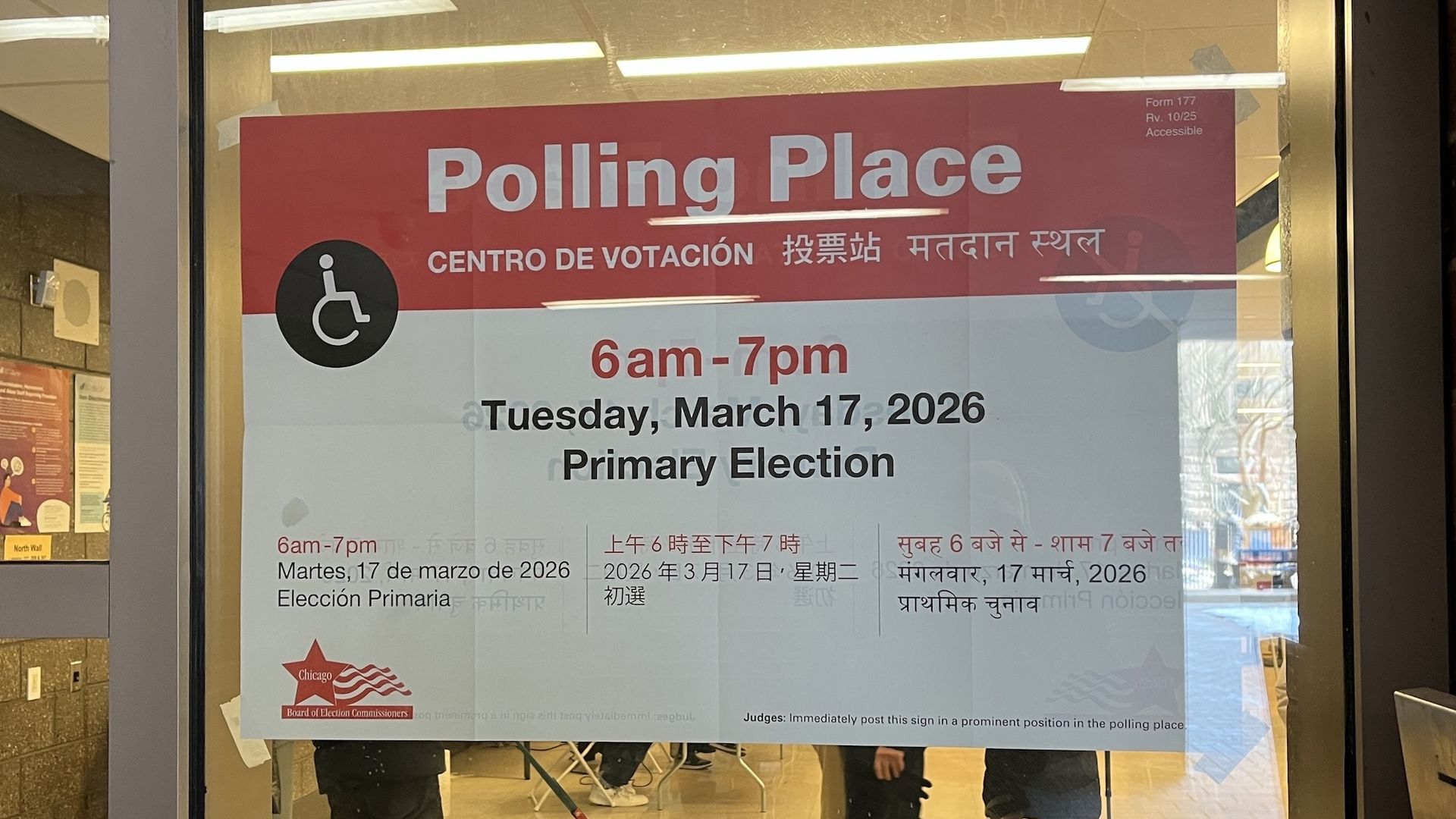 Glass door poster reading "Polling Place" in white on red with a wheelchair icon; shows 6am–7pm, Tuesday, March 17, 2026 Primary Election.