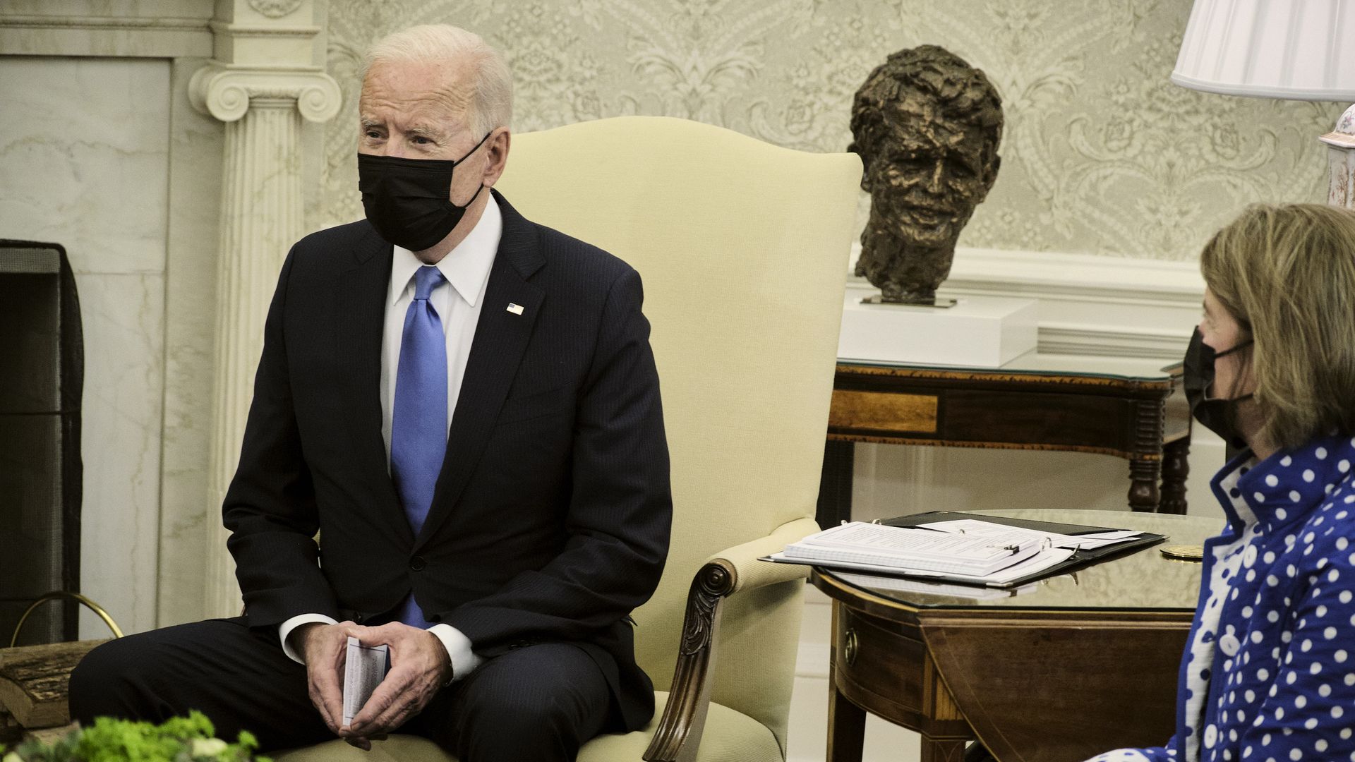 Photo of a masked Joe Biden sitting in a chair in the Oval Office