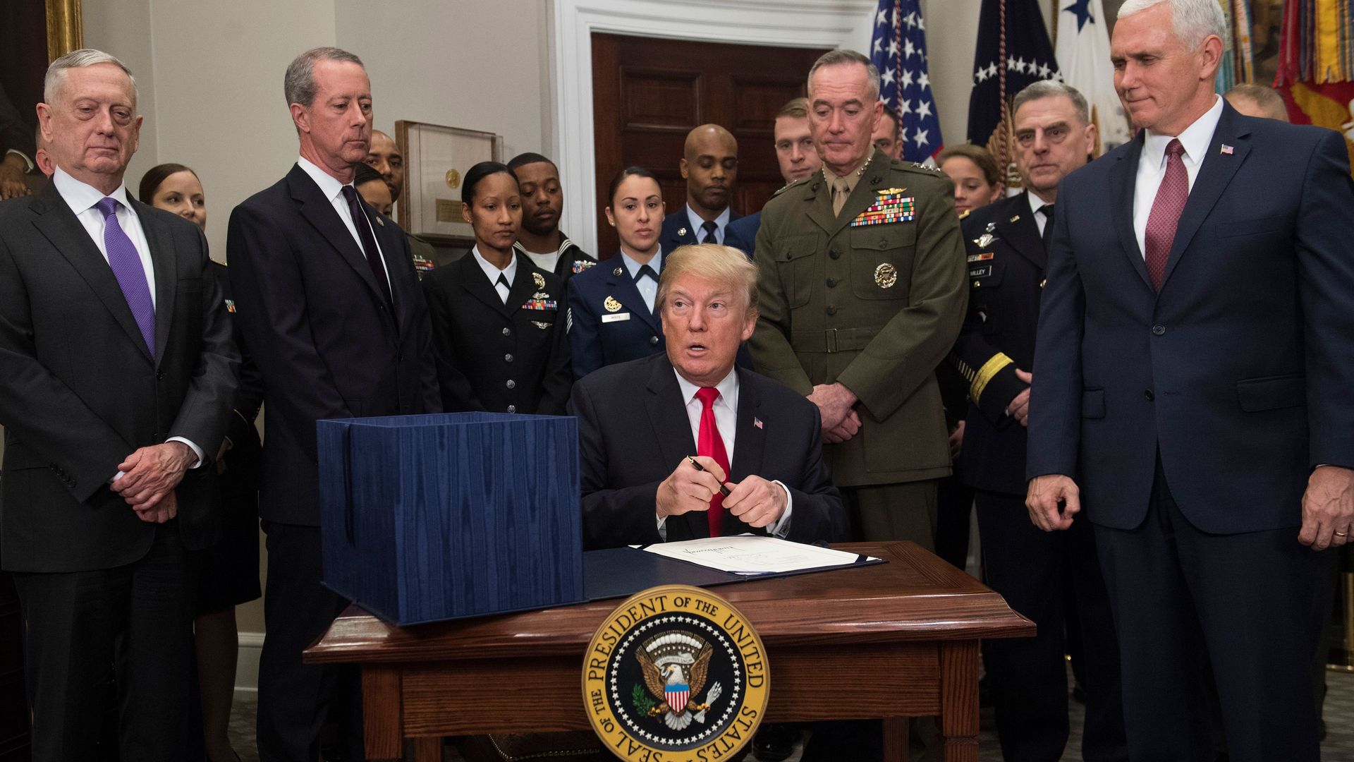 President Donald Trump, surrounded by military officials and members of Congress. 