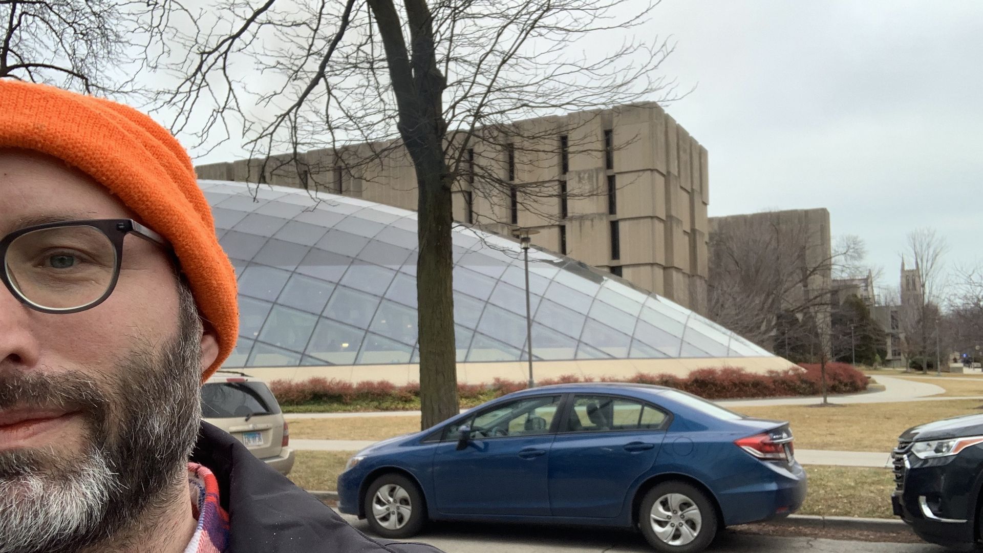 Photo of a man standing in front of a bubble-shaped library 