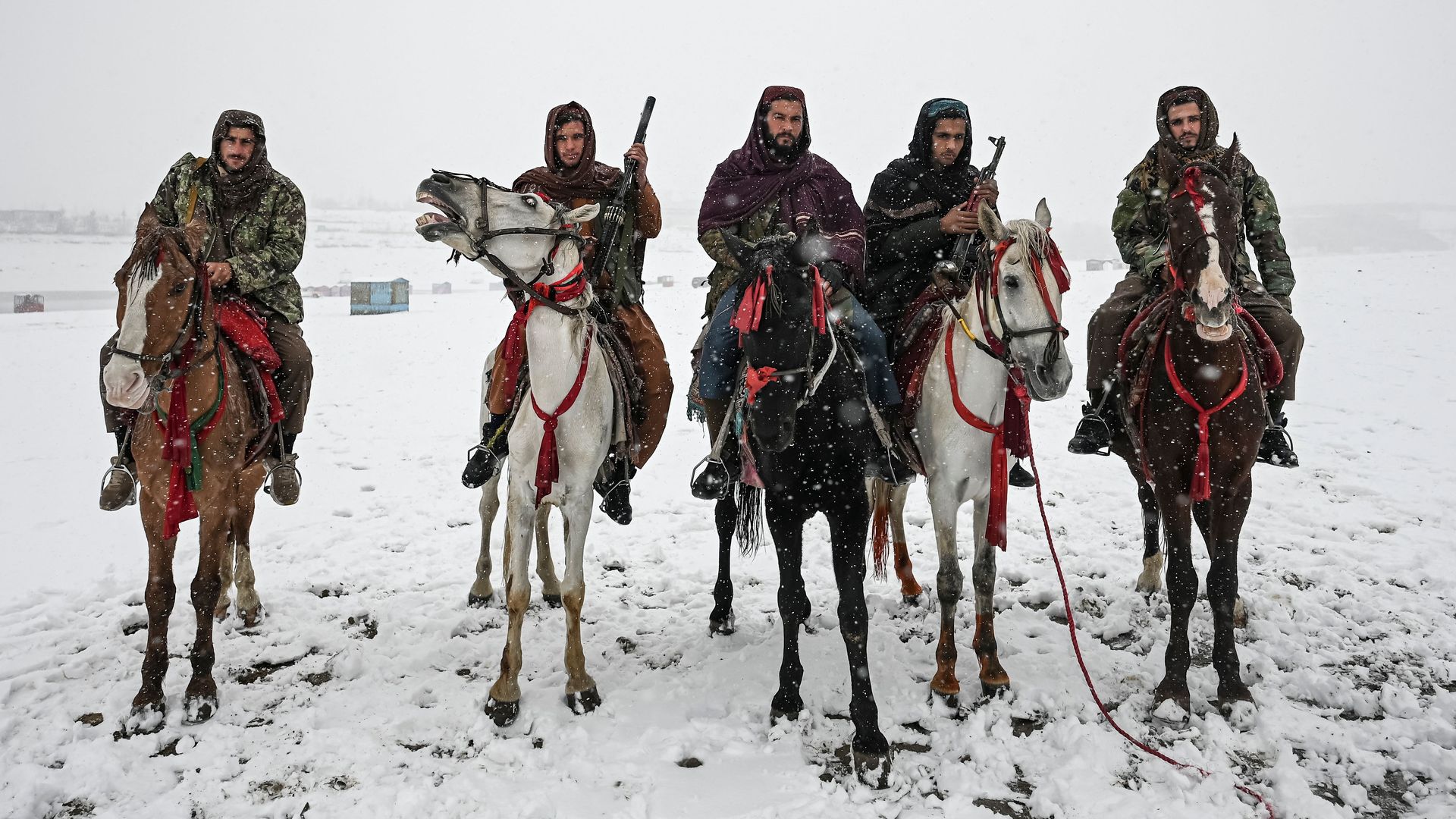 Taliban fighters riding horses during a snowfall at the Qargha lake in Kabul on January 3.