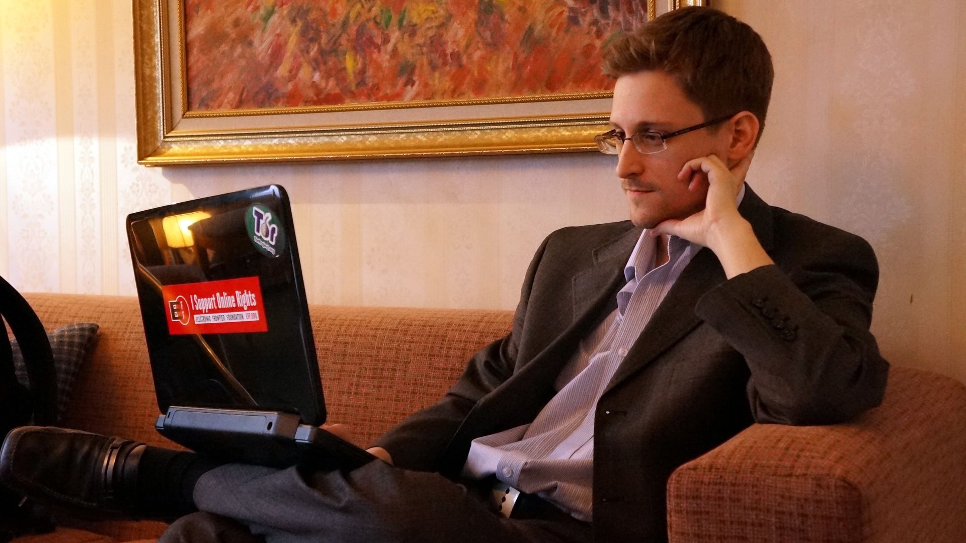 Snowden looking at a laptop.