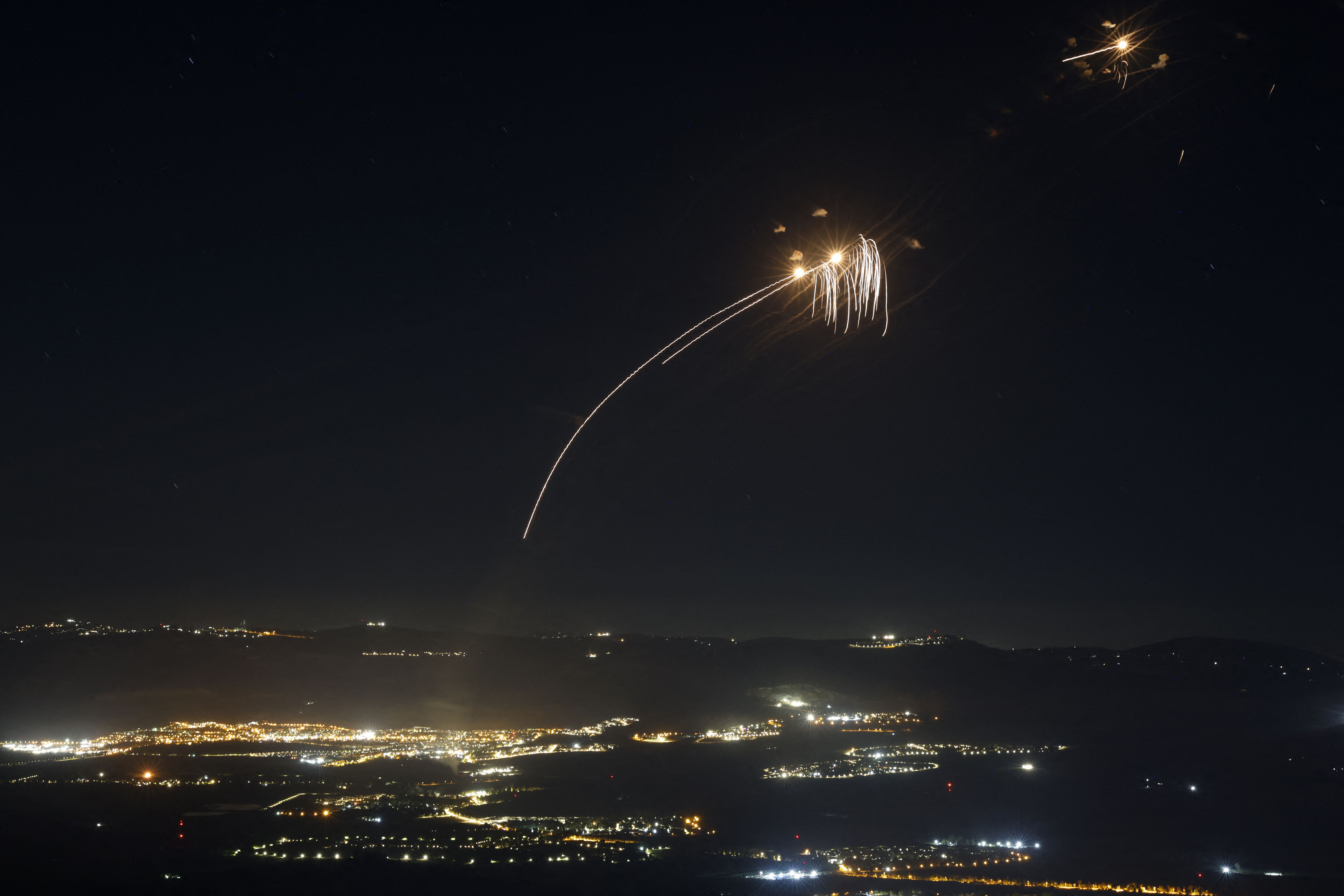 Rockets fired from southern Lebanon are intercepted by Israel's Iron Dome air defence system over the Upper Galilee region in northern Israel