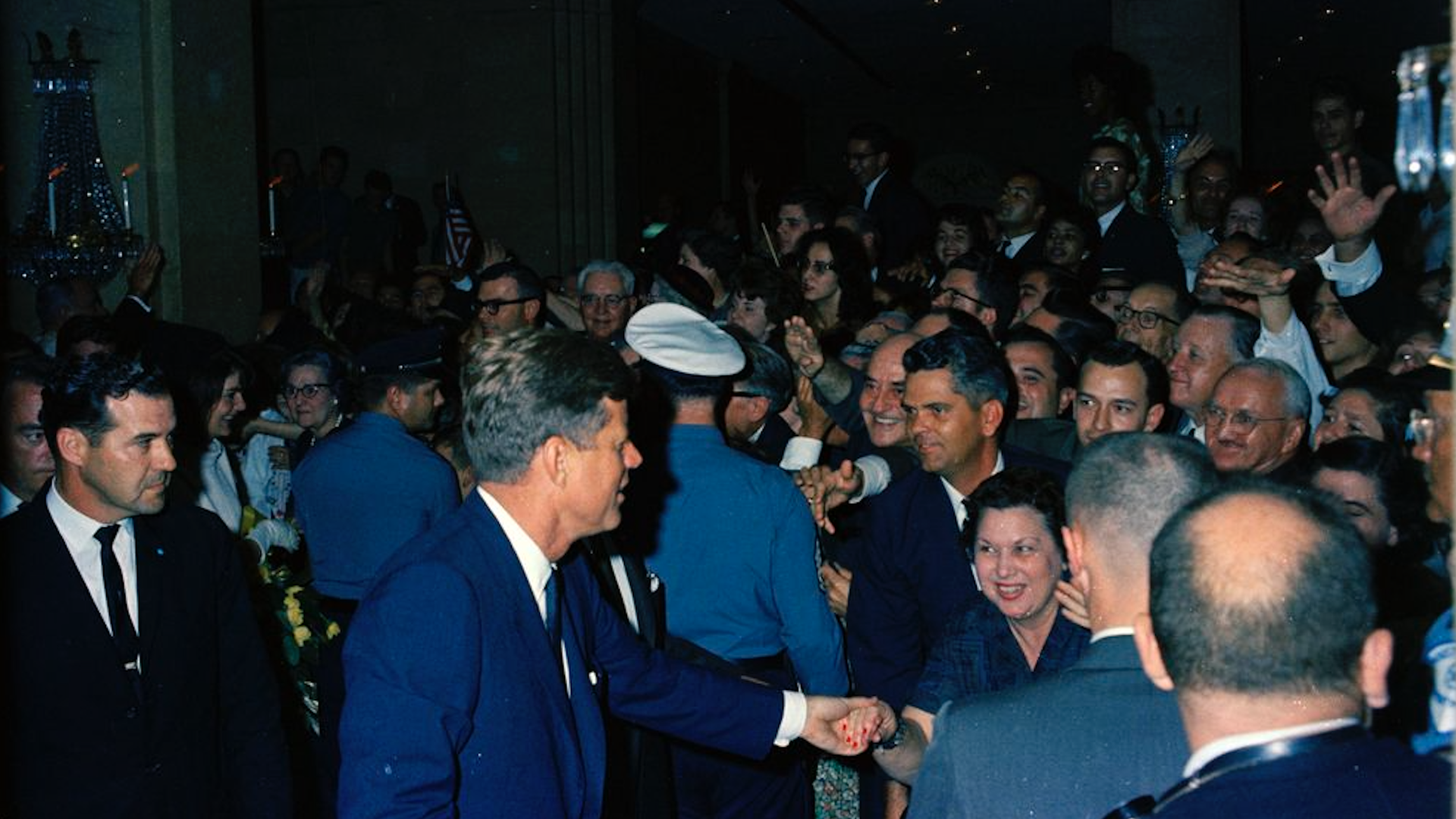 President John F. Kennedy and First Lady Jacqueline Kennedy (partially hidden at left) greet visitors upon their arrival at the Rice Hotel in Houston.