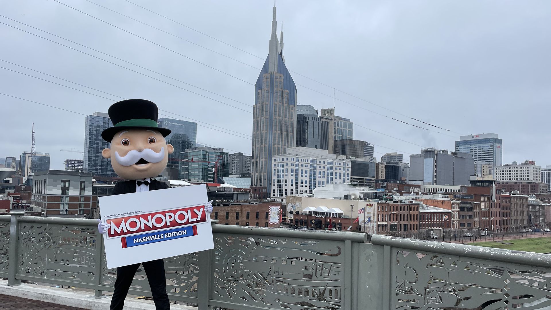 Rich Uncle Pennybags poses in front of the Nashville skyline.