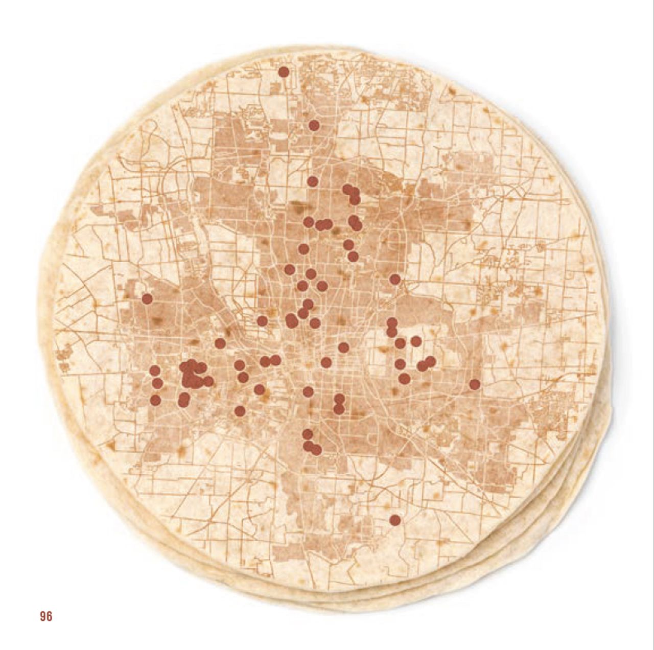 Top view of three stacked tortillas with a detailed city map and red dots marking specific locations printed on the top tortilla, all on a white background.