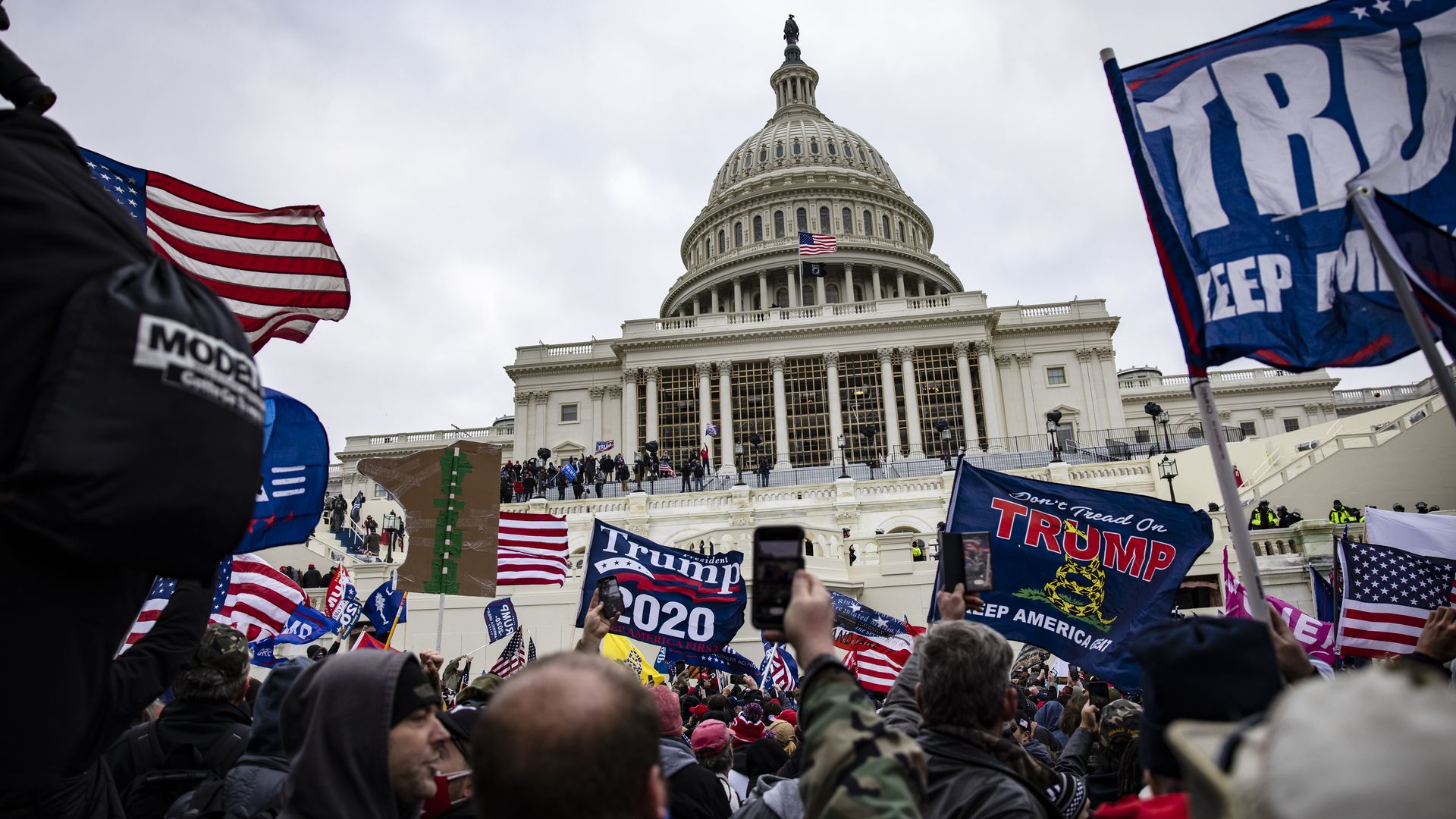 Picture of the Capitol building surrounded by Trump supporters
