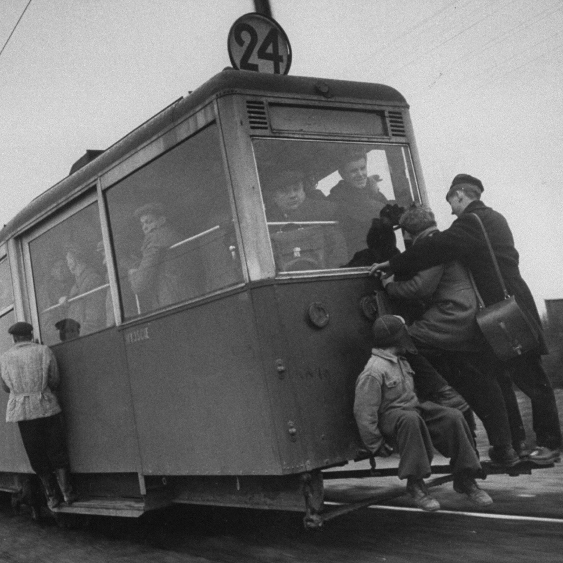 People hanging off a streetcar.