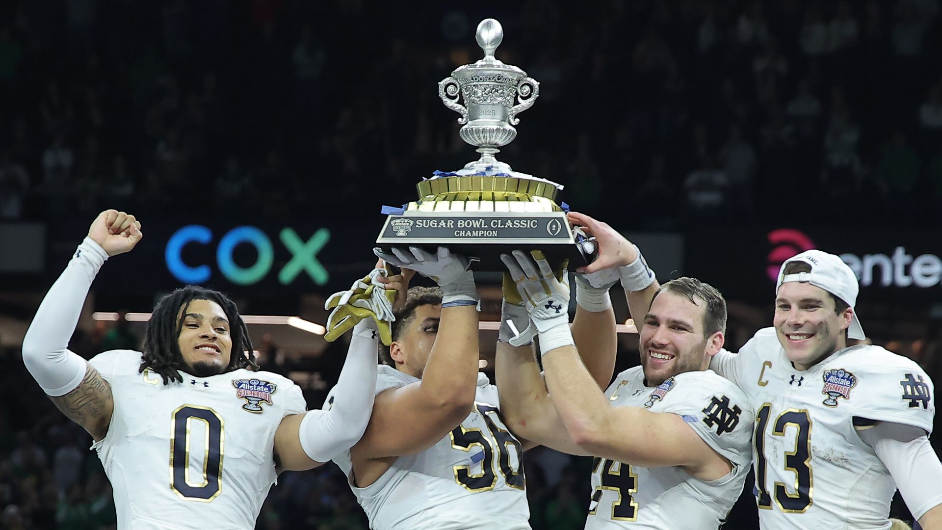 Four football players holding a trophy