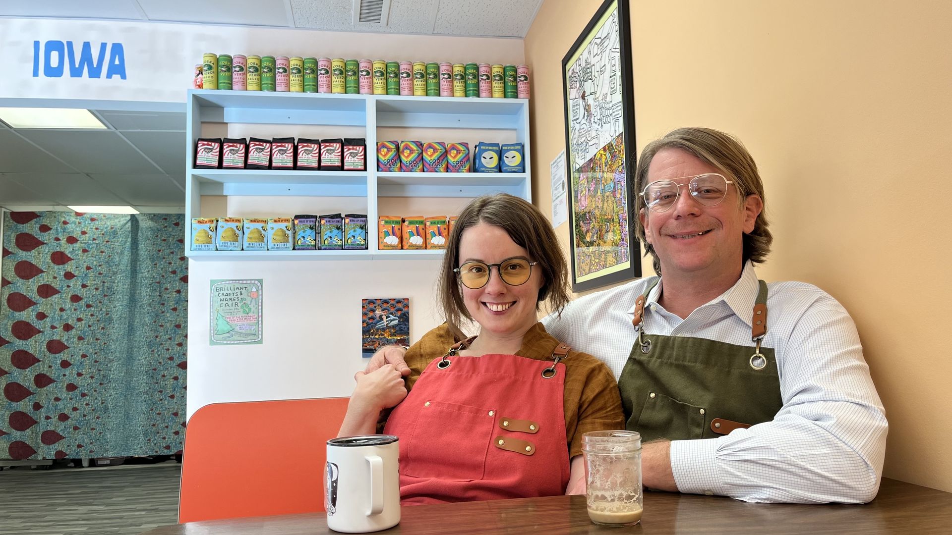 A woman and a man sitting in a booth at the Wake Up Iowa Coffee shop