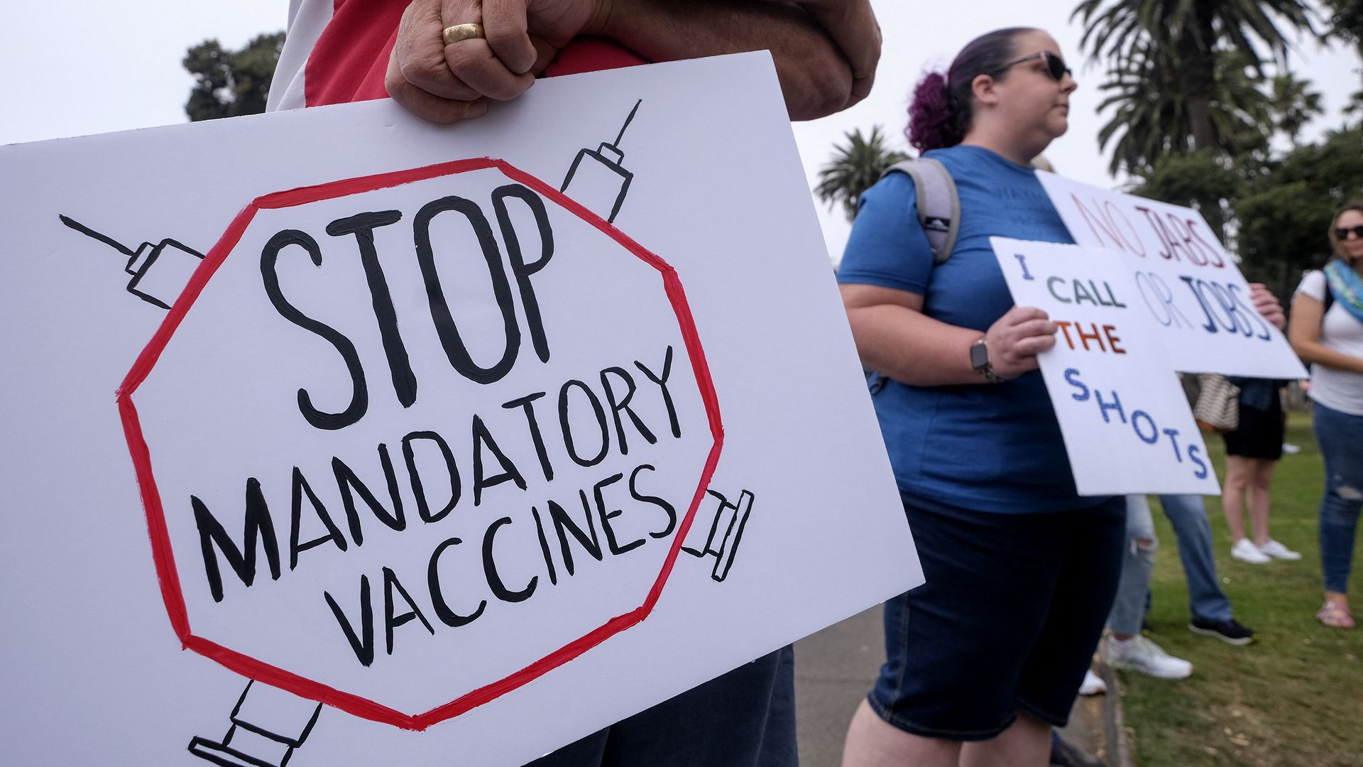 Picture of a sign that says "STOP MANDATORY VACCINES"