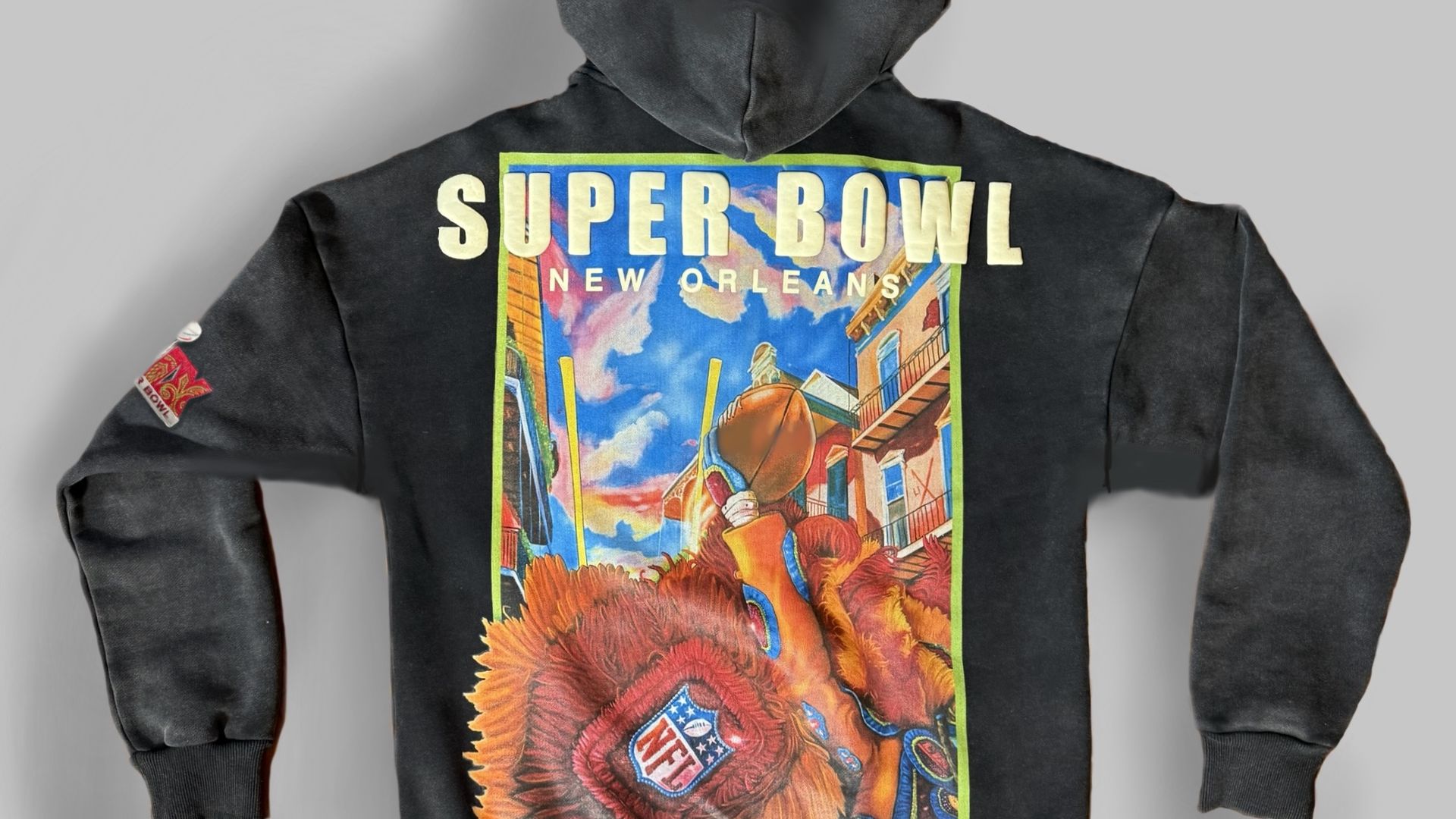 The back of a hoodie with a colorful New Orleans street design. The hoodie says Super Bowl across the top.