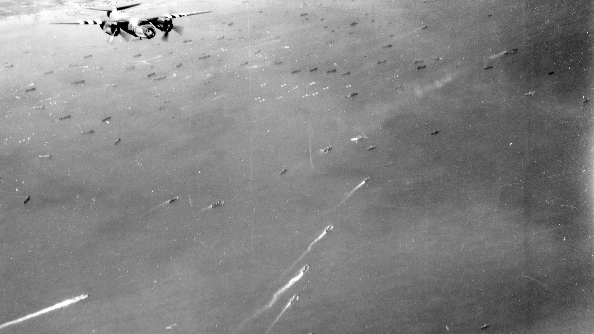 Black and white photo of B26 over Normandy Beach, D-Day