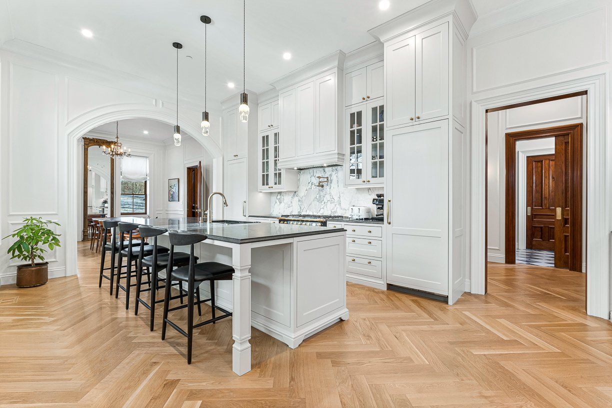 A real estate photo of a chef's kitchen alongside a dining room at 31 Monument Square in Charlestown. 