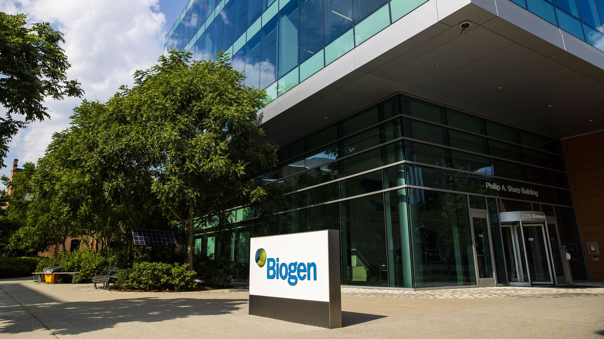 An office building with Biogen's blue and white sign in front.