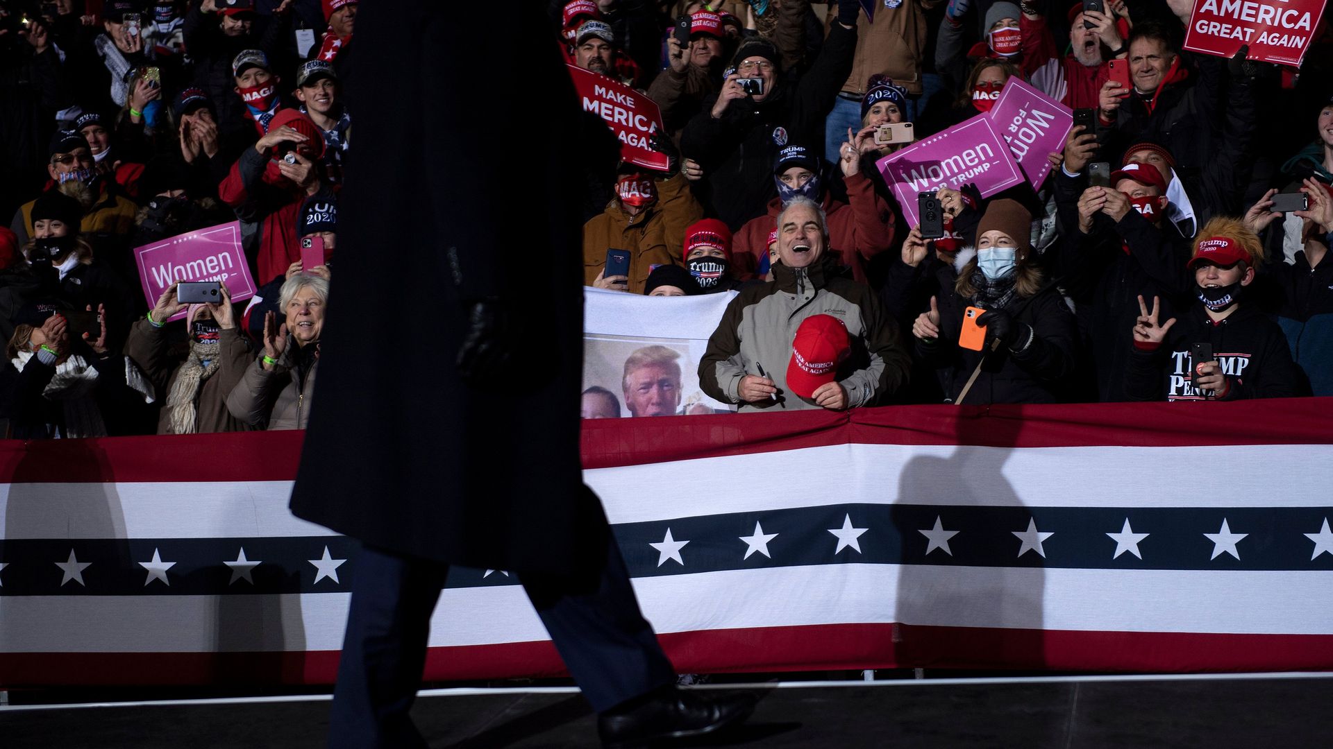 Trump's silhouette walks by a crowd 
