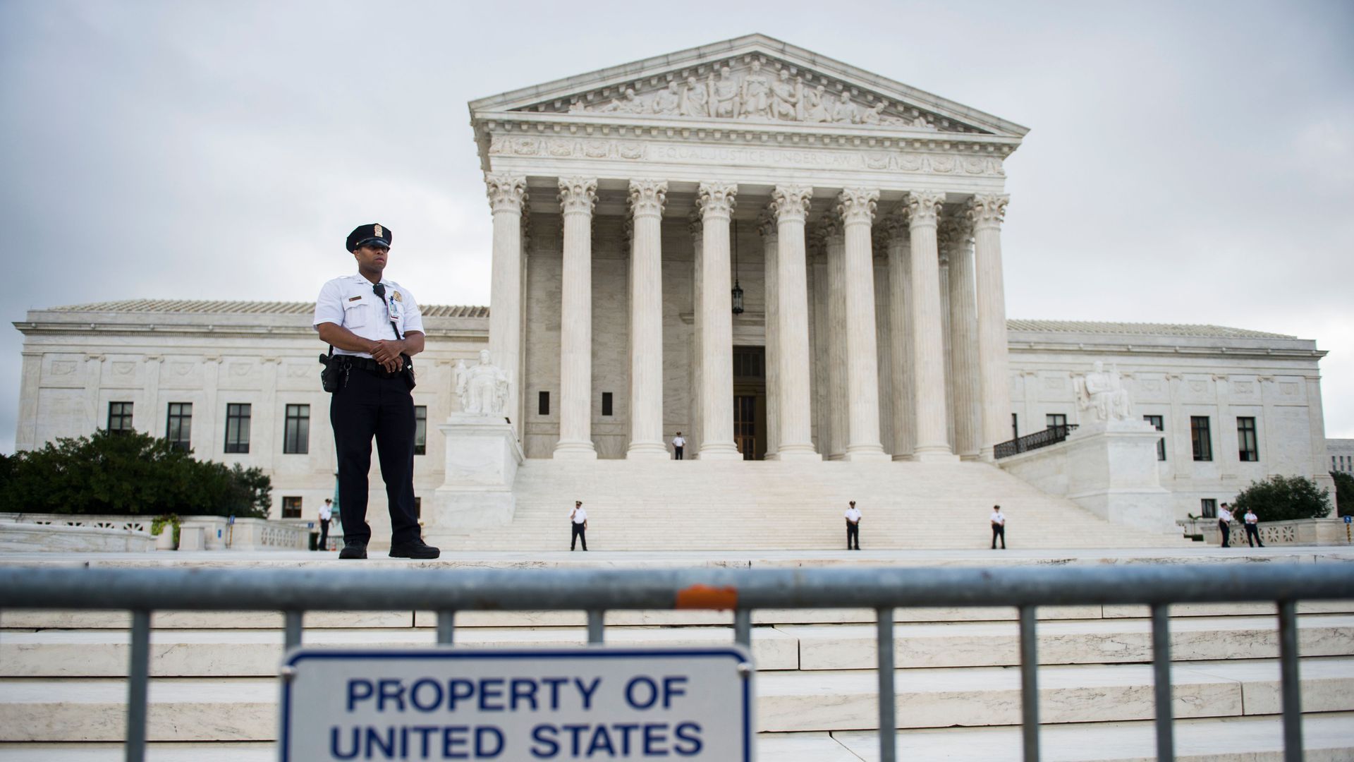 A security officer stands guard on the steps of the Supreme Court