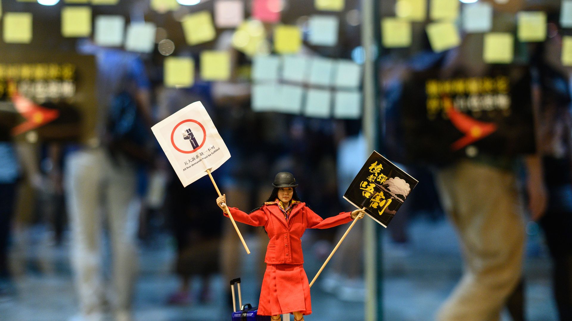 Flight attendant doll holding protest signs in Hong Kong