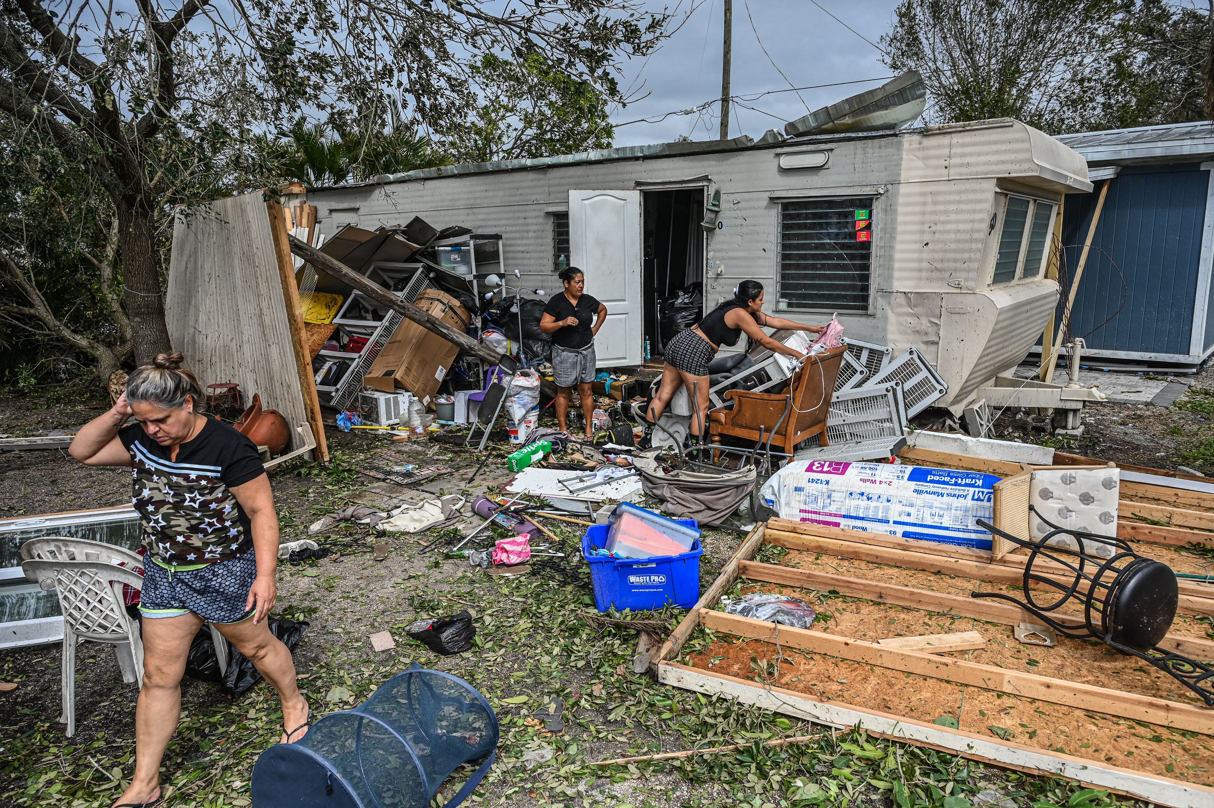 people clean hurricane debris found around their mobile home
