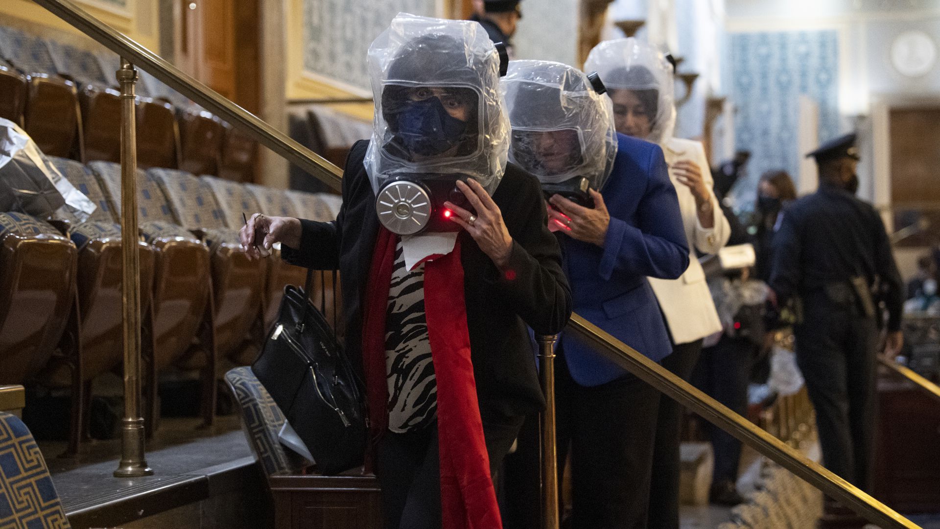 Rep. Ann McLane Kuster, in blue, takes cover as rioters attempt to break in to the House Chamber on Jan. 6. 