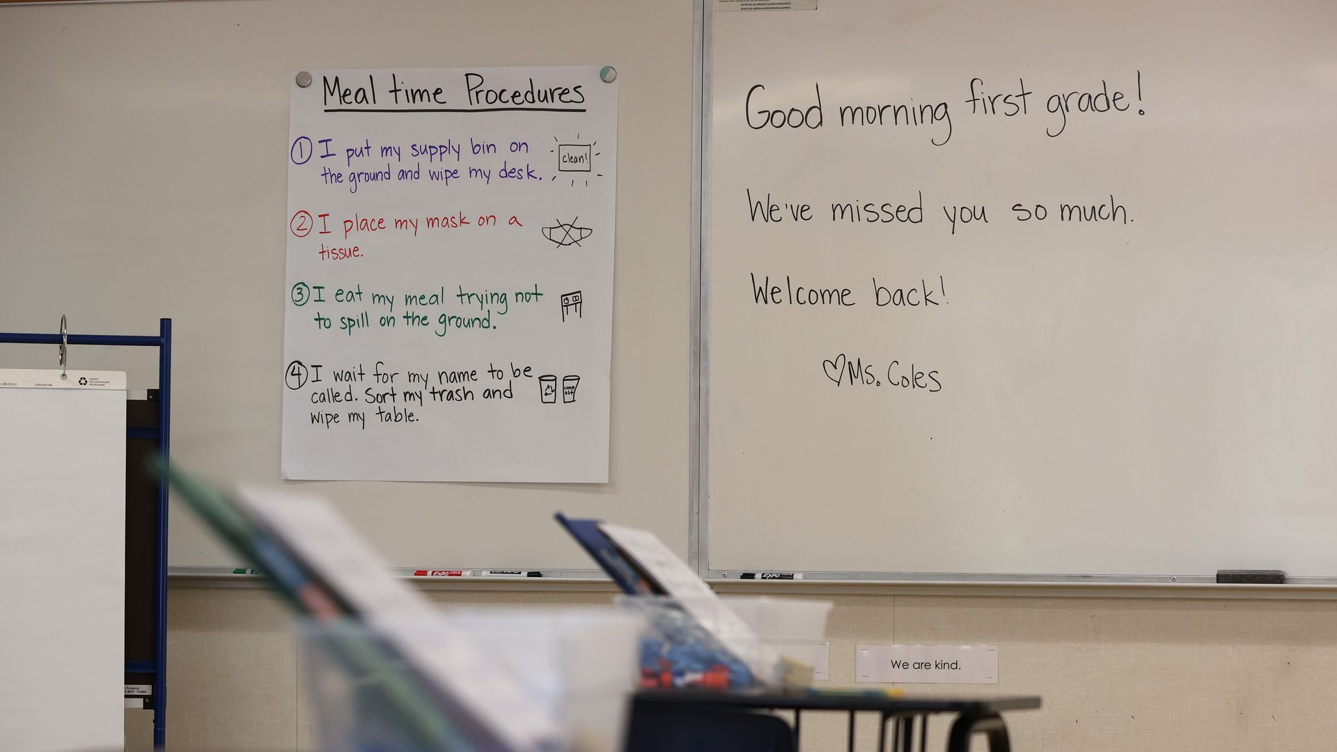 Photo of school desks and a white board in a classroom