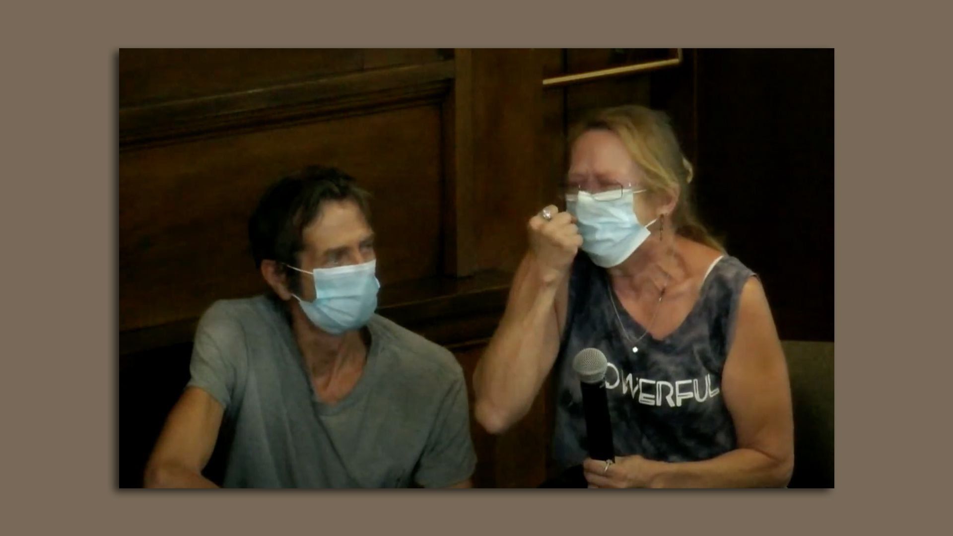 Catherine Manhart raises her fist in the air at Monday's Des Moines City Council meeting.
