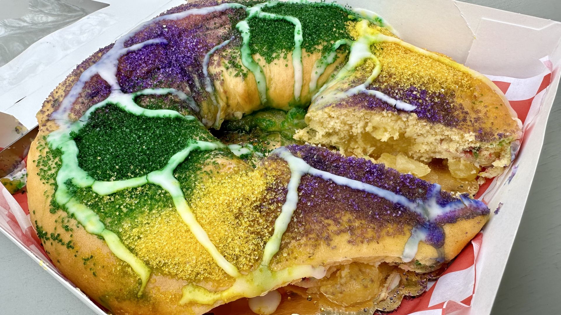 Photo shows a purple, green and gold king cake.