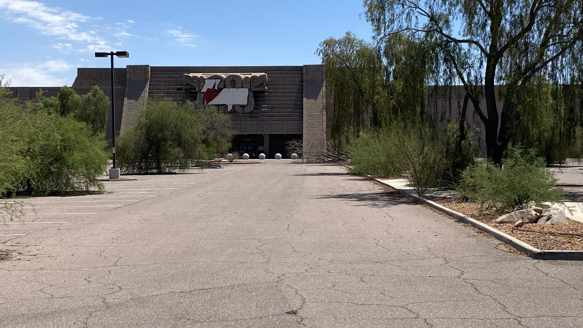 An abandoned big box store with Aztec temple imagery on the exterior.