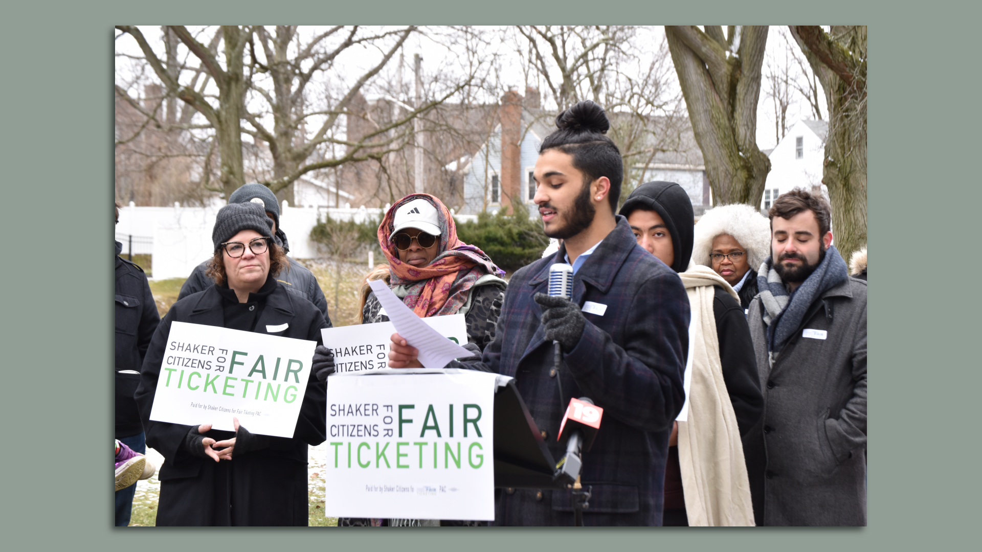 Teen organizer Ethan Khorana speaks at a microphone on a winter day, with crowd behind him