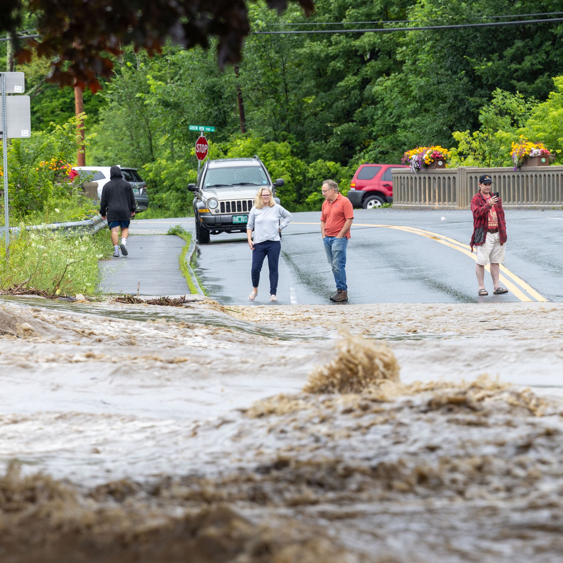 Onlookers check out a flooded road on July 10, 2023 in Chester, Vermont. 