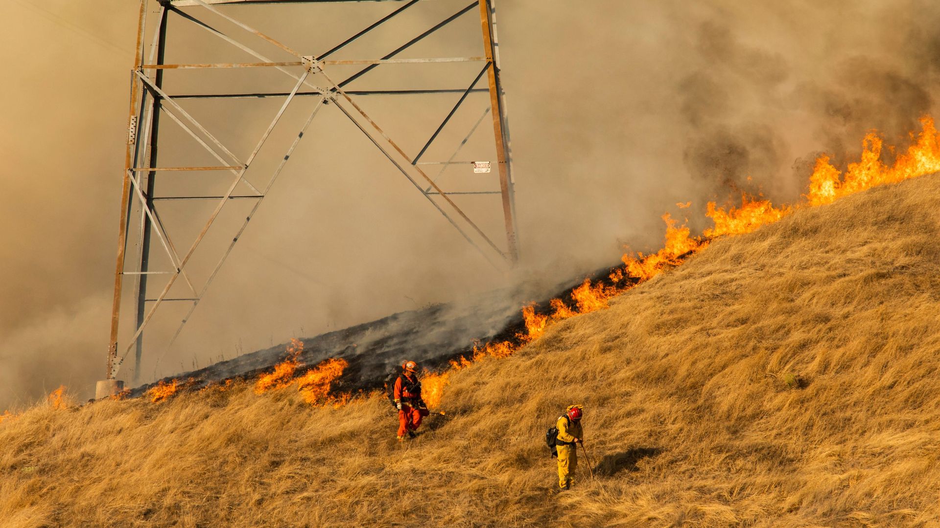 Firefighters set a back fire along a hillside near PG&E power lines during firefighting operations to battle the Kincade Fire in Healdsburg, California on October 26, 2019.