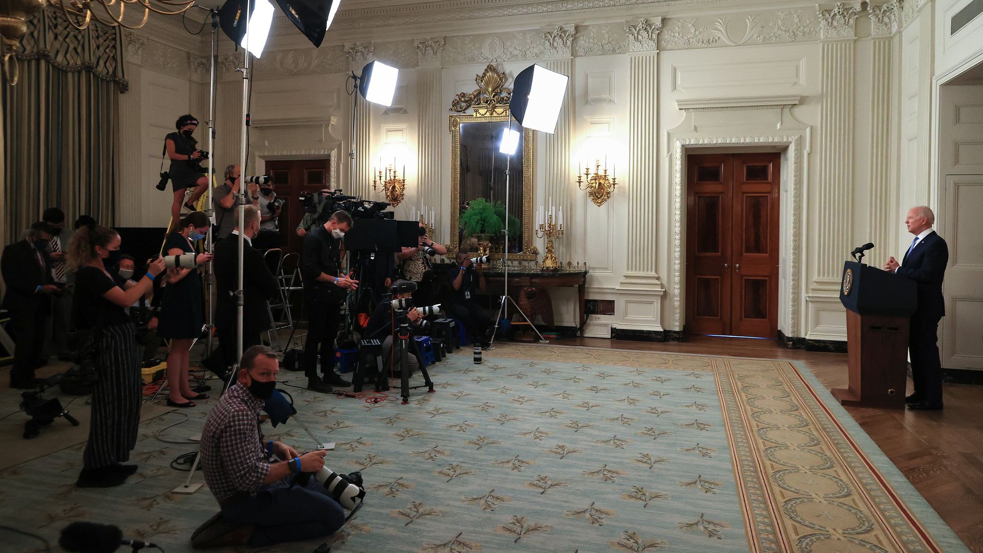 Biden speaks in front of lights and cameras at the White House