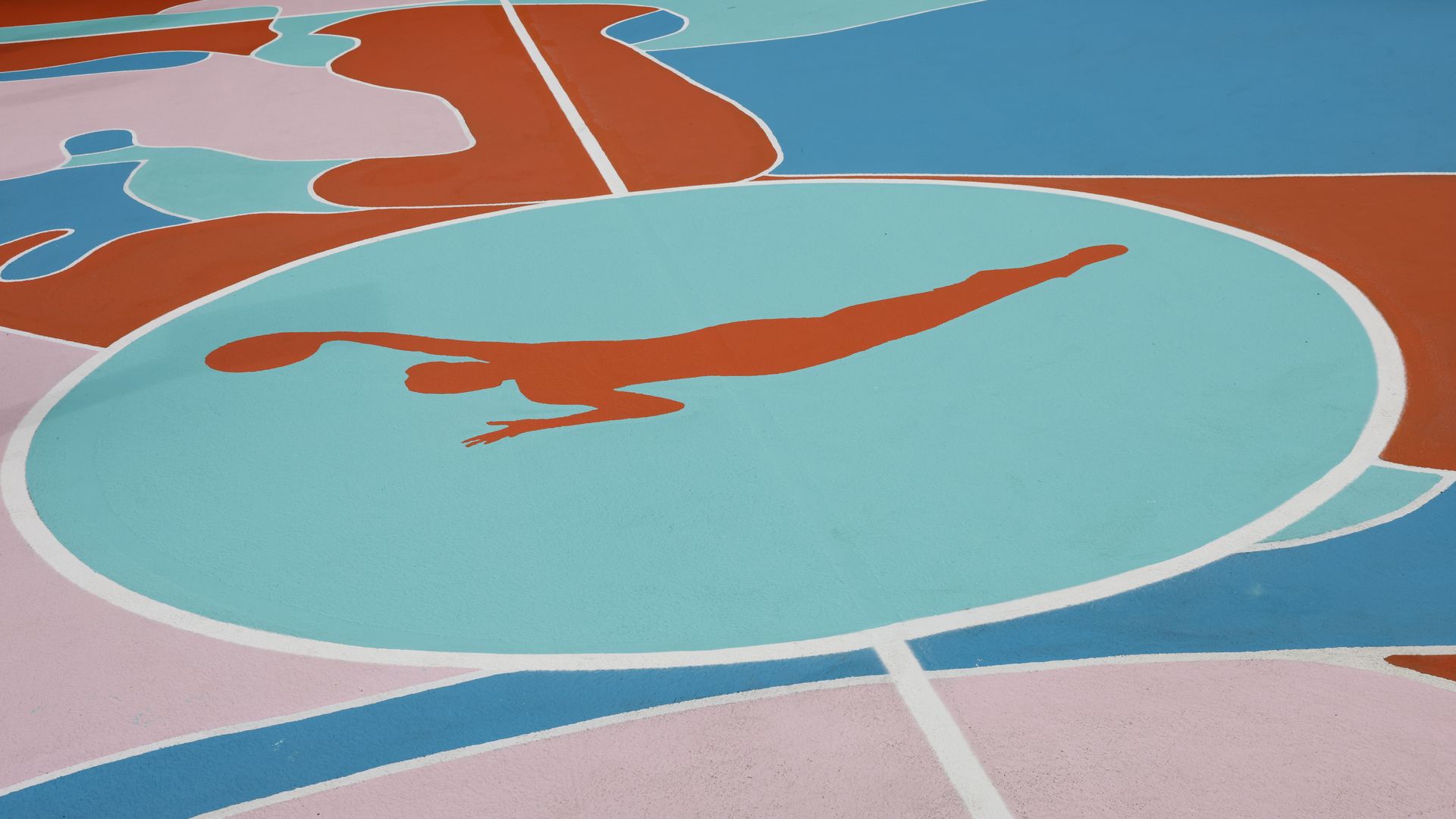 Multicolored floor of a basketball court with the logo of a woman with a basketball in hand.