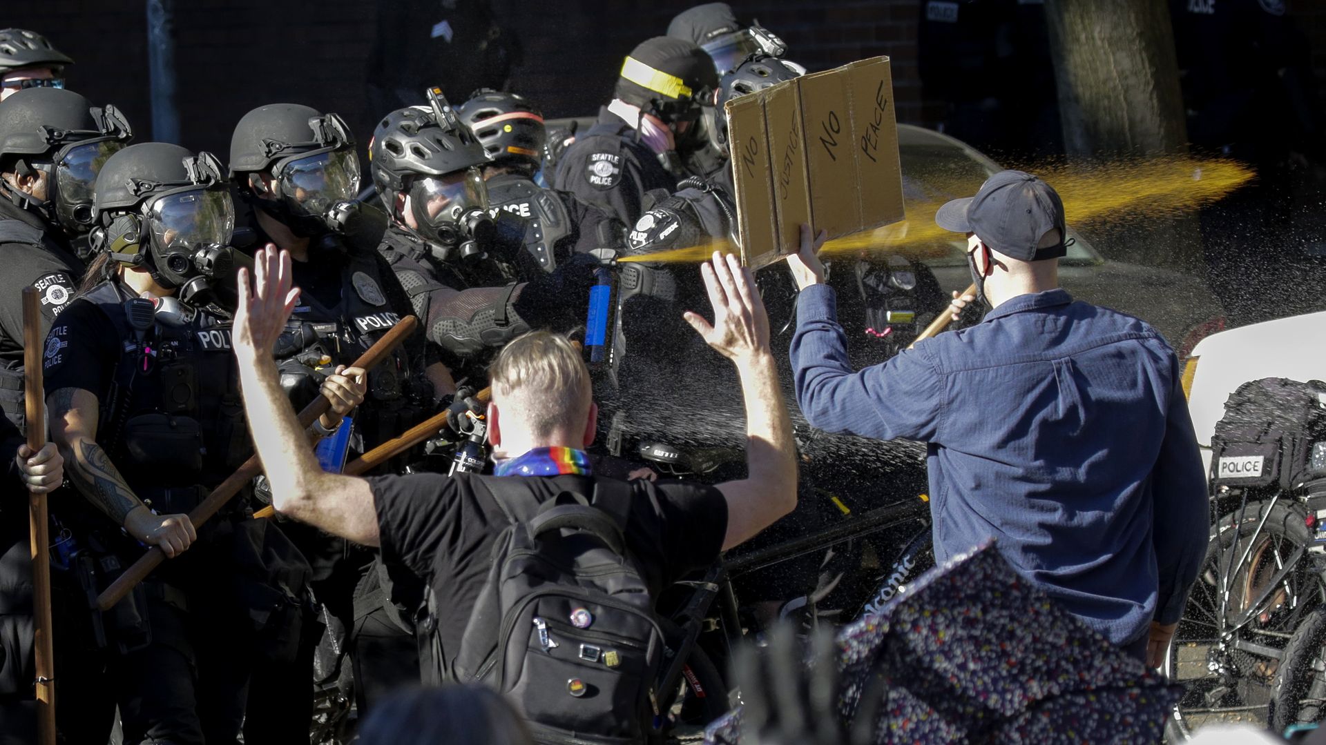 Seattle police officers deploy pepper spray as they clash with protesters 