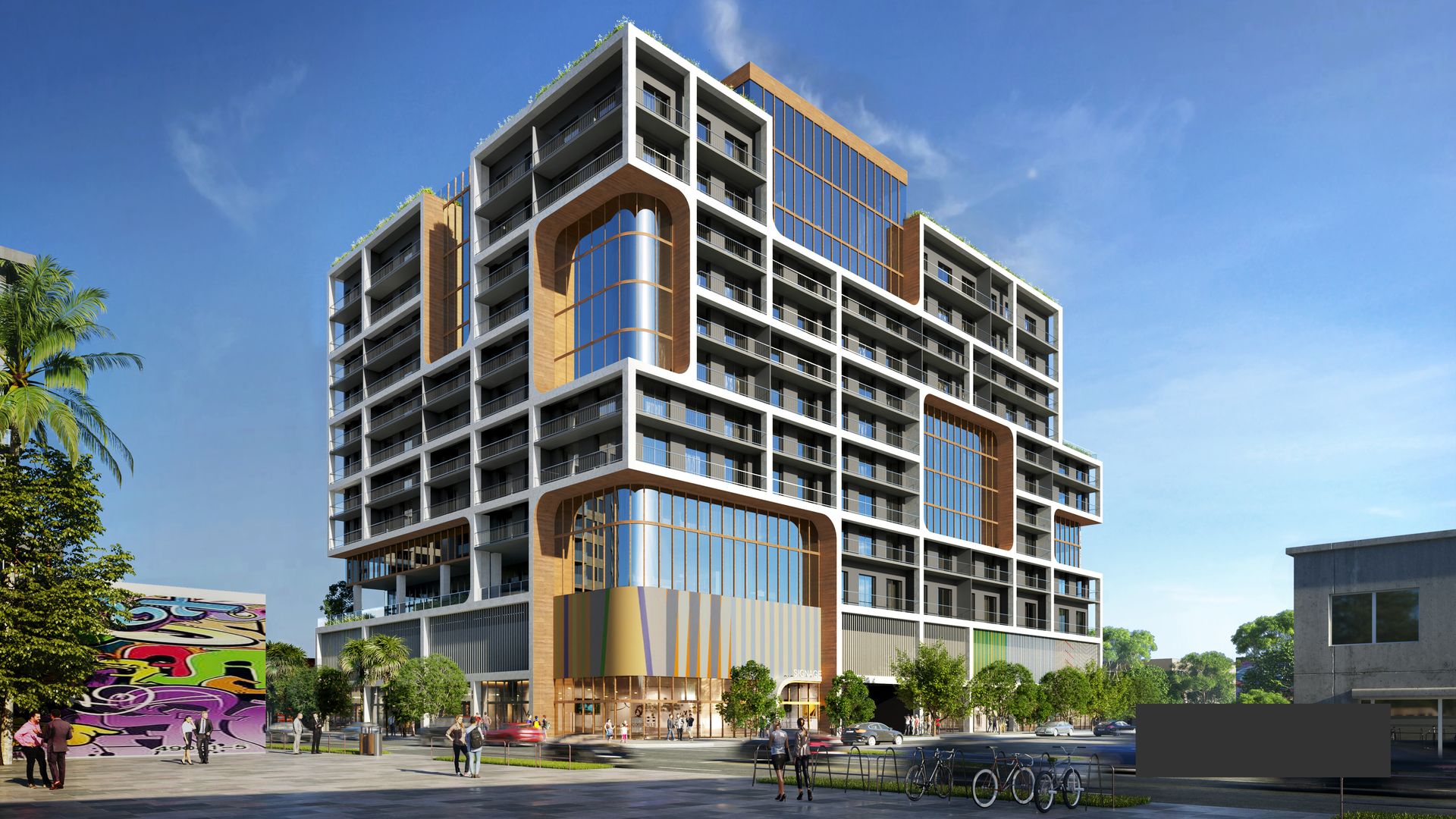 Modern multi-story building with white grid frame and wooden accents, large glass windows, balconies, and ground-level shops. People and bikes in plaza under clear blue sky.