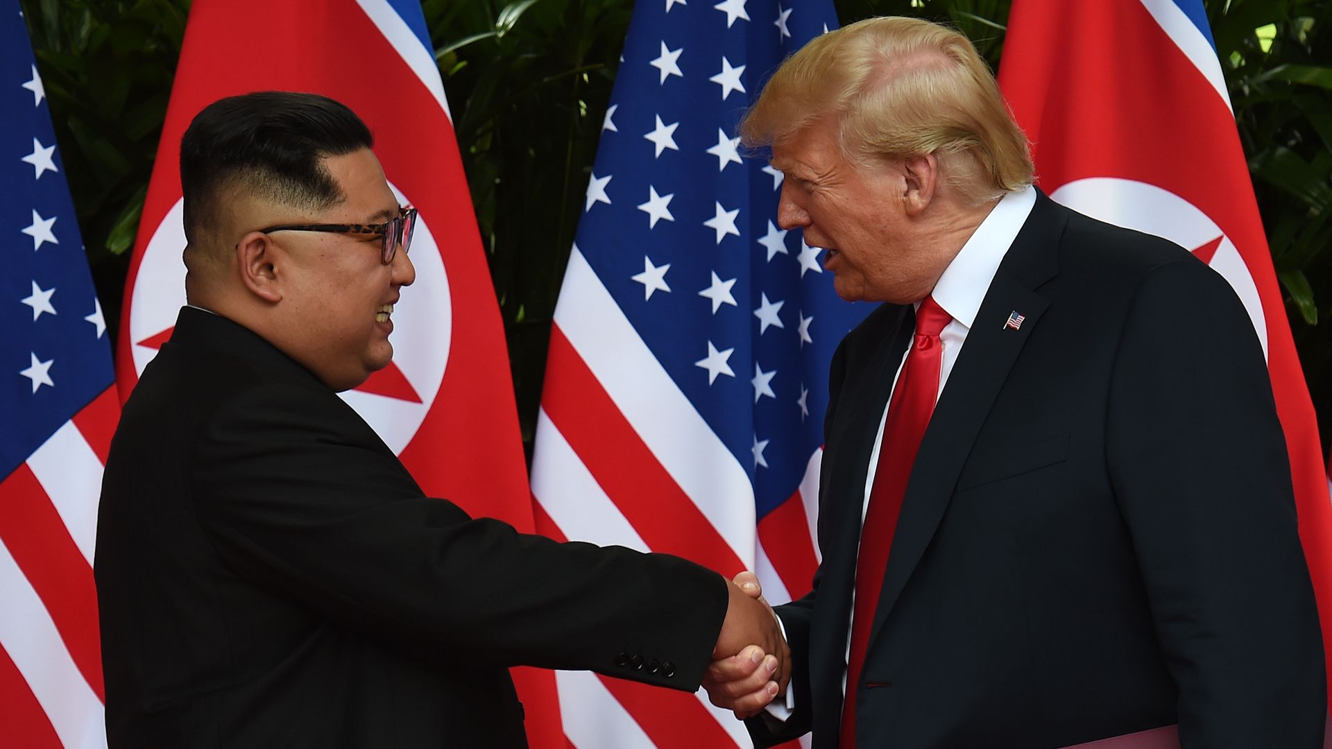 Kim Jong-un and Donald Trump shake hands