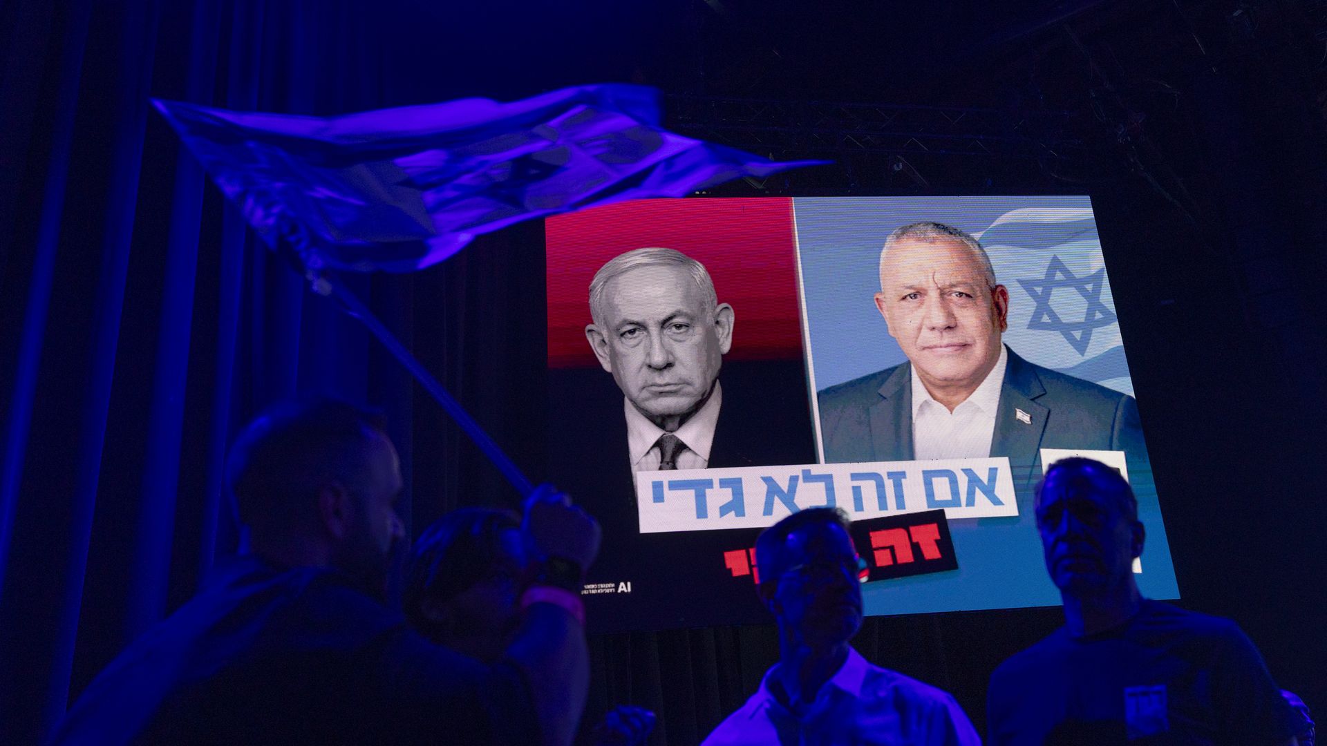 Images of Benjamin Netanyahu (left) and Gadi Eisenkot appear on large screens at an election campaign rally in Tel Aviv.