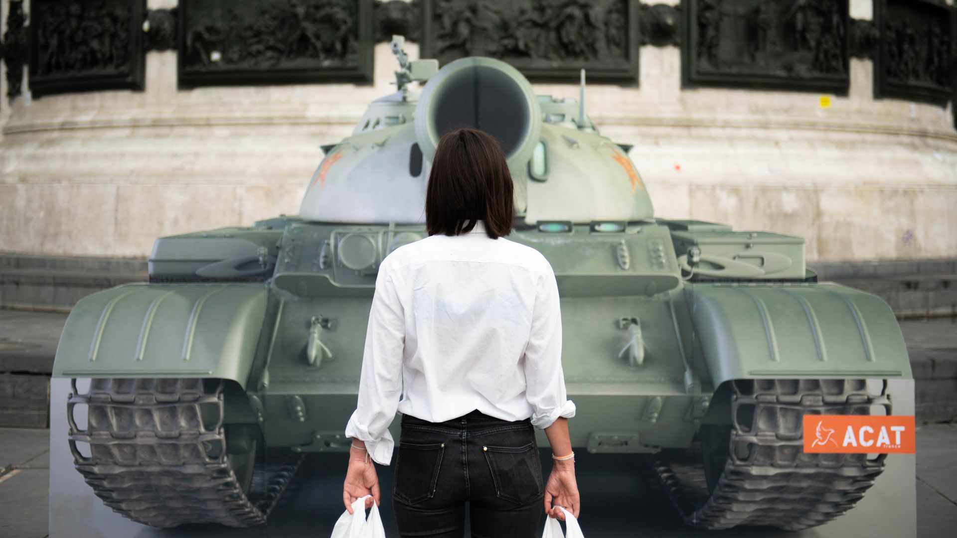 in front of a fake tank on the Place de la Republique square in Paris to mark the 30th anniversary of Tiananmen Square crackdown in China