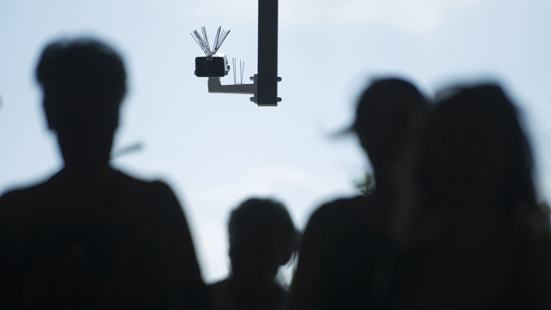 Photo of human silhouettes and a security camera