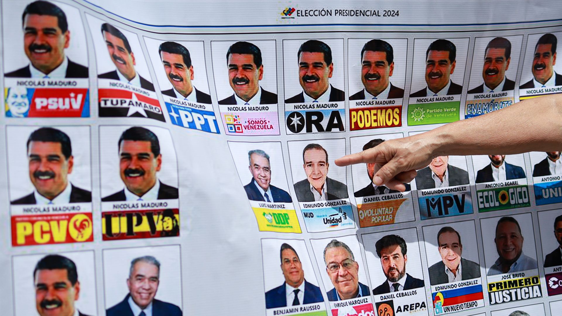 A finger points to an enlarged sample ballot for Venezuela's July 28 elections that shows multiple pictures of President Nicolas Maduro