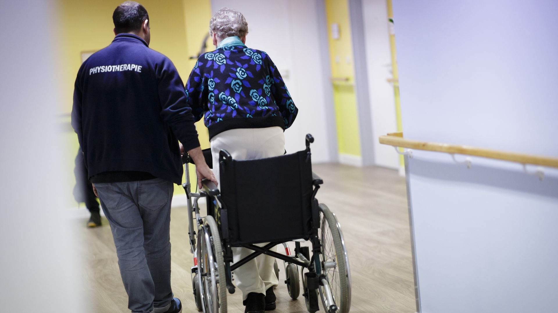 A caregiver helps an elderly woman