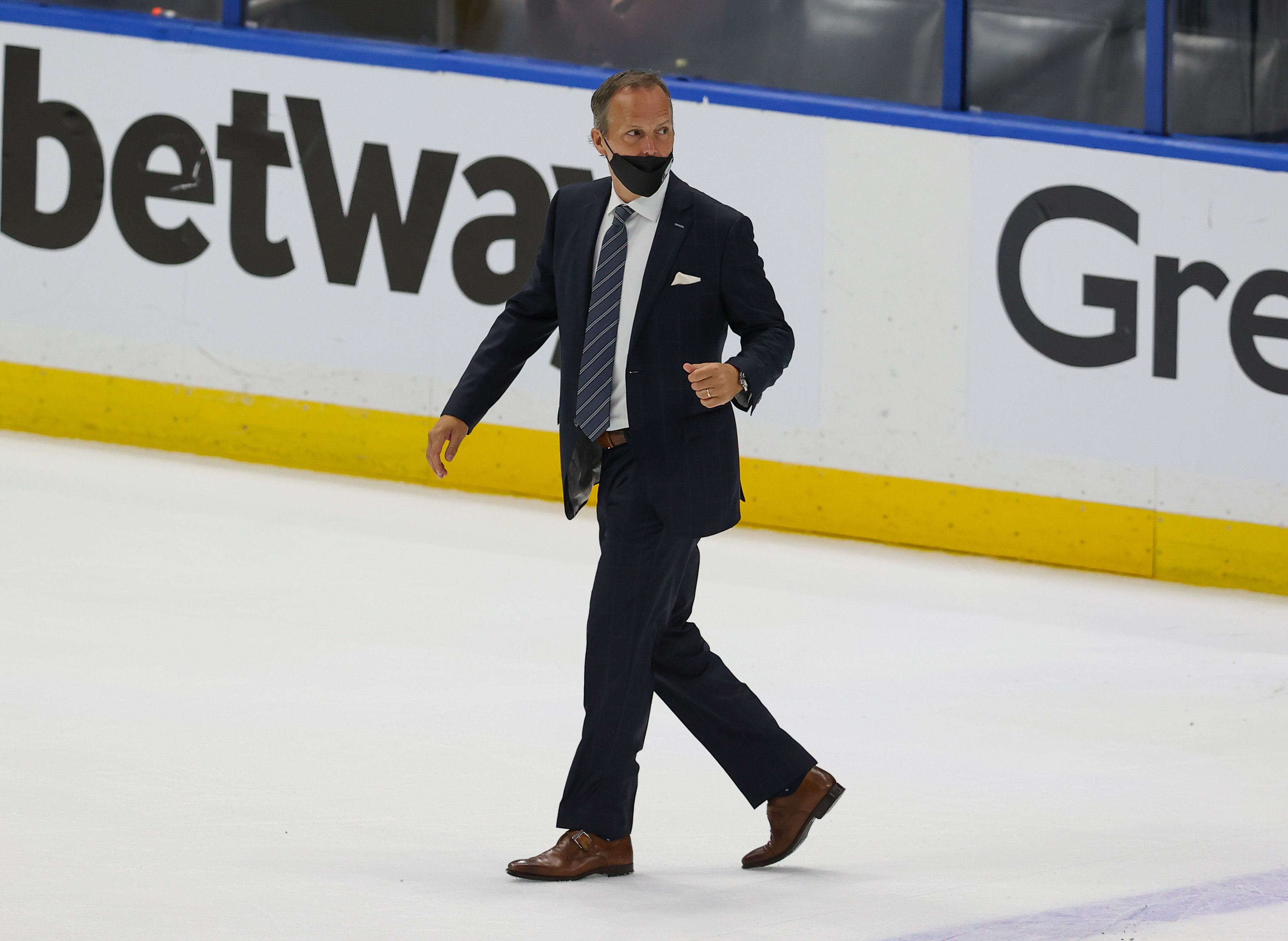 Head Coach Jon Cooper of the Tampa Bay Lightning walks across the ice.