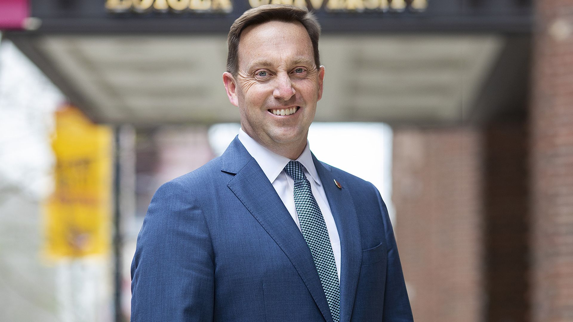 Mark Reed smiles in a blue suit.