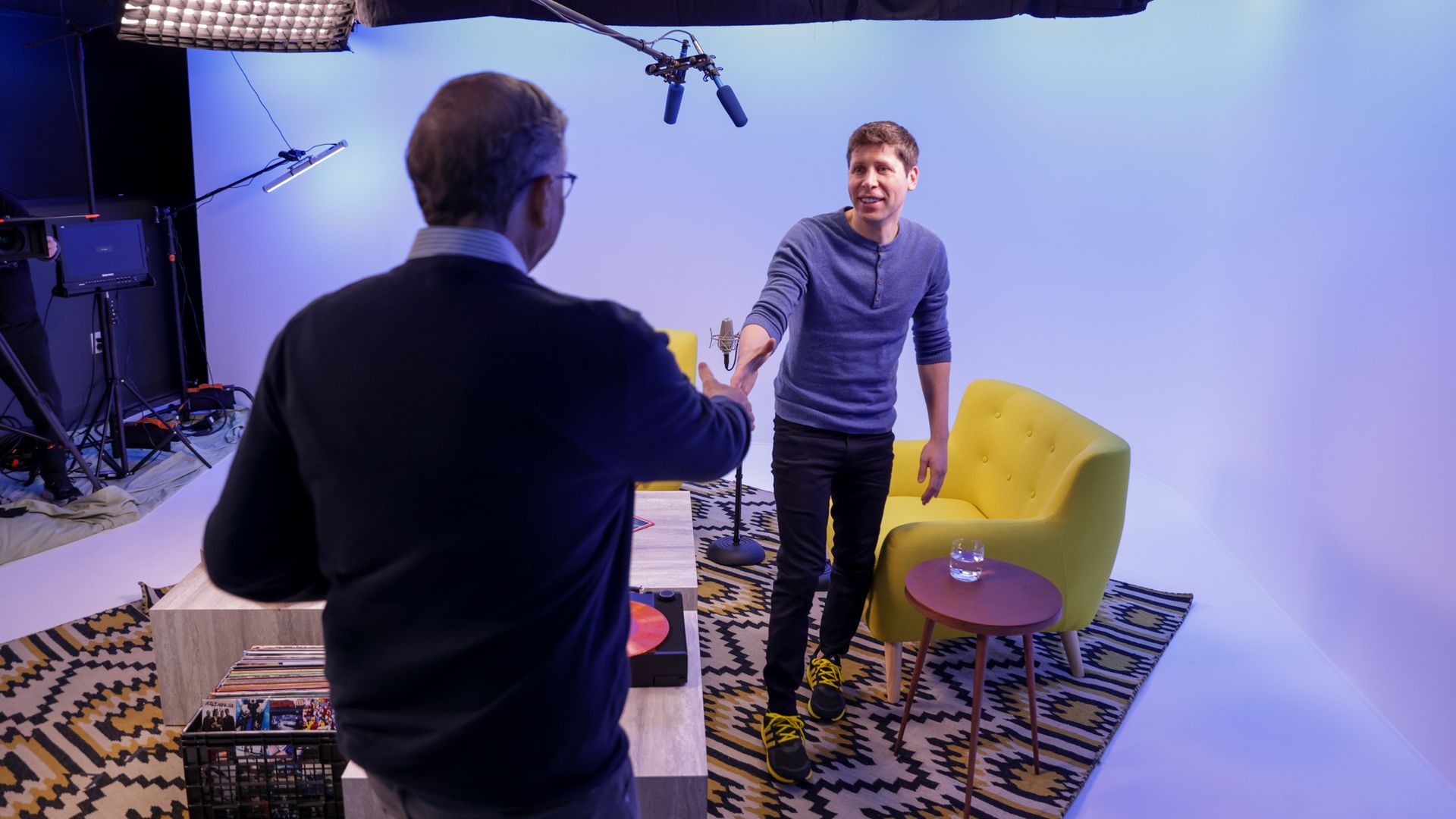 Bill Gates shakes hands with Sam Altman as they record a podcast together.