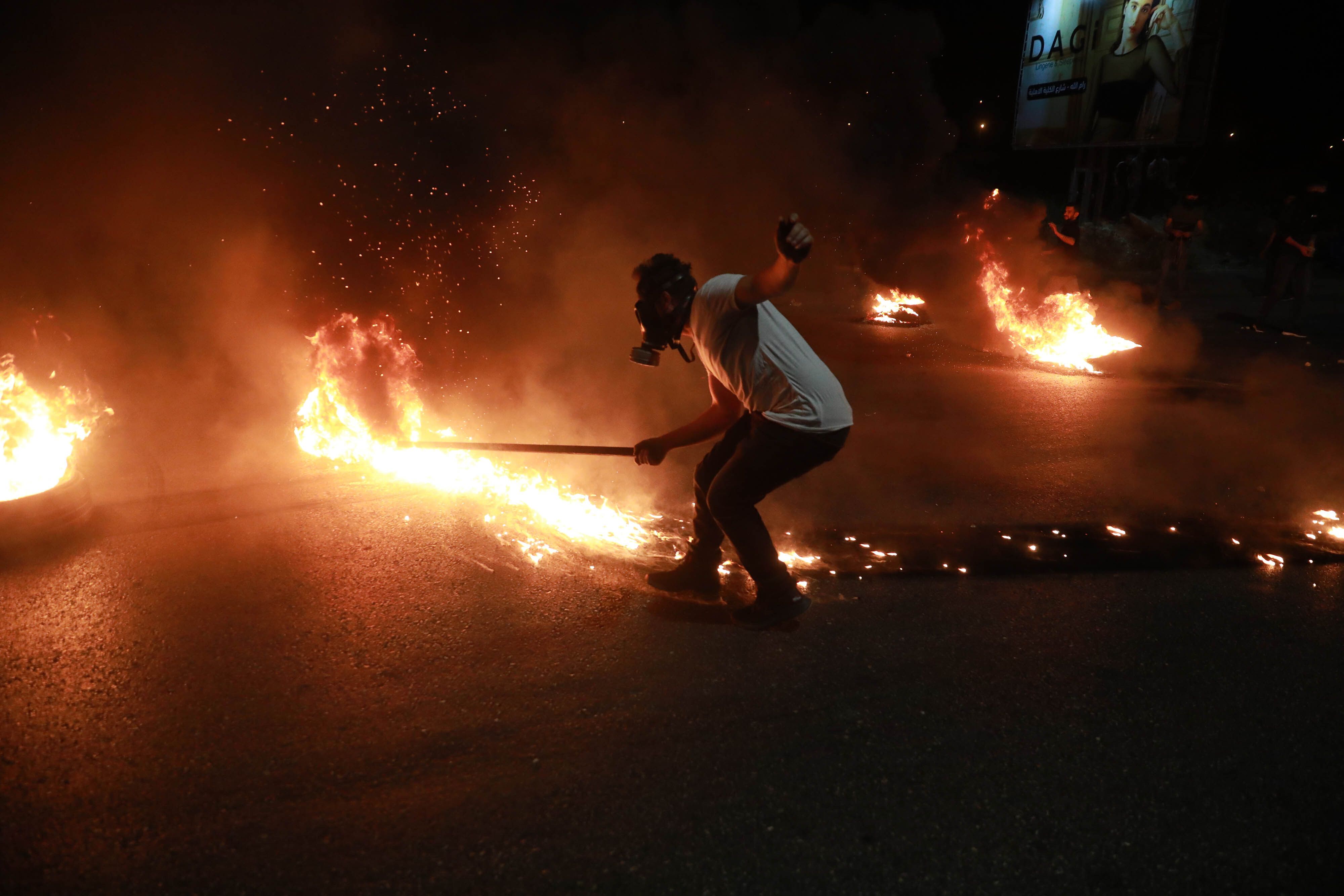 Palestinians burn tires during a protest at the Beit El checkpoint in Ramallah, West Bank on May 12