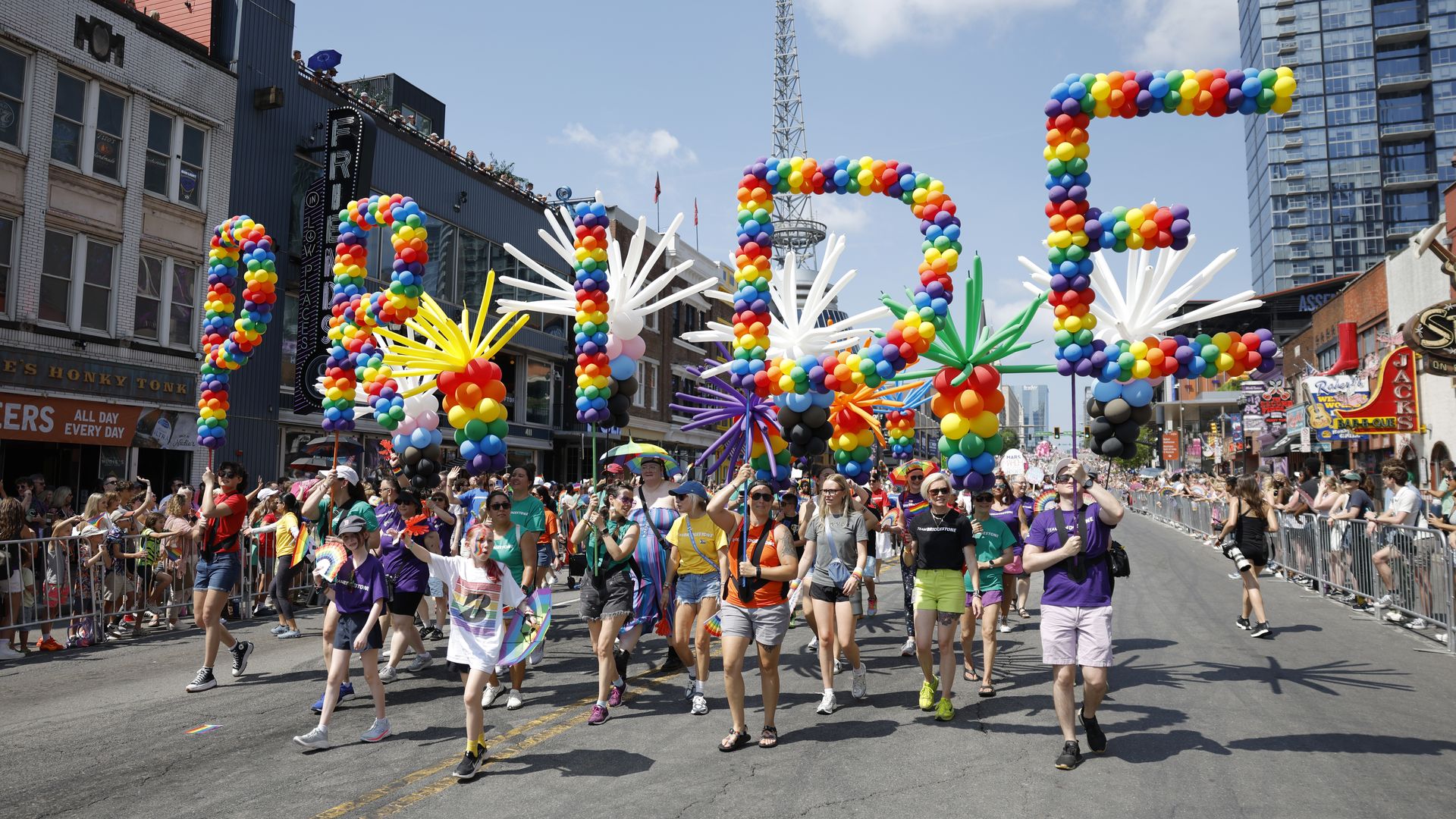 Parade participants hold balloons spelling out P-R-I-D-E during the Nashville Pride 2025 parade