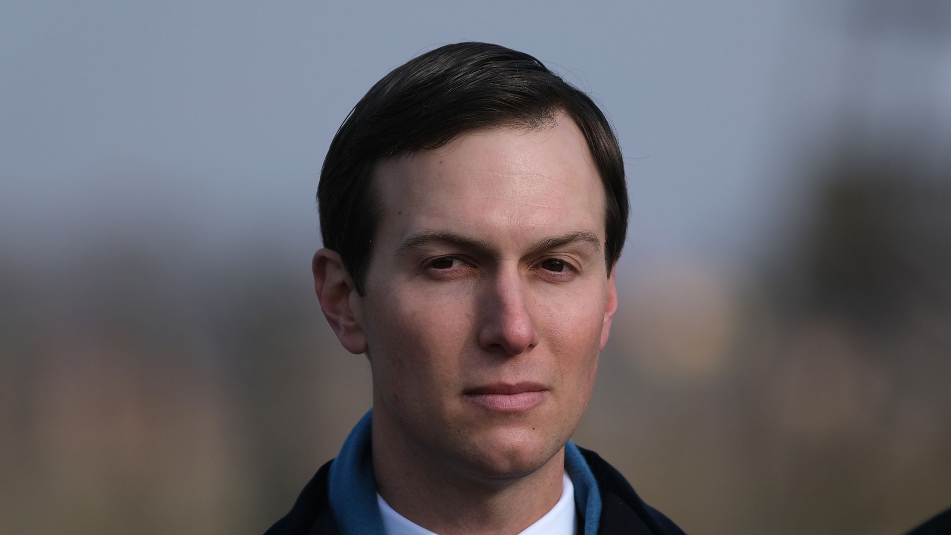 In this image, Jared Kushner looks at the camera in a suit and jacket.