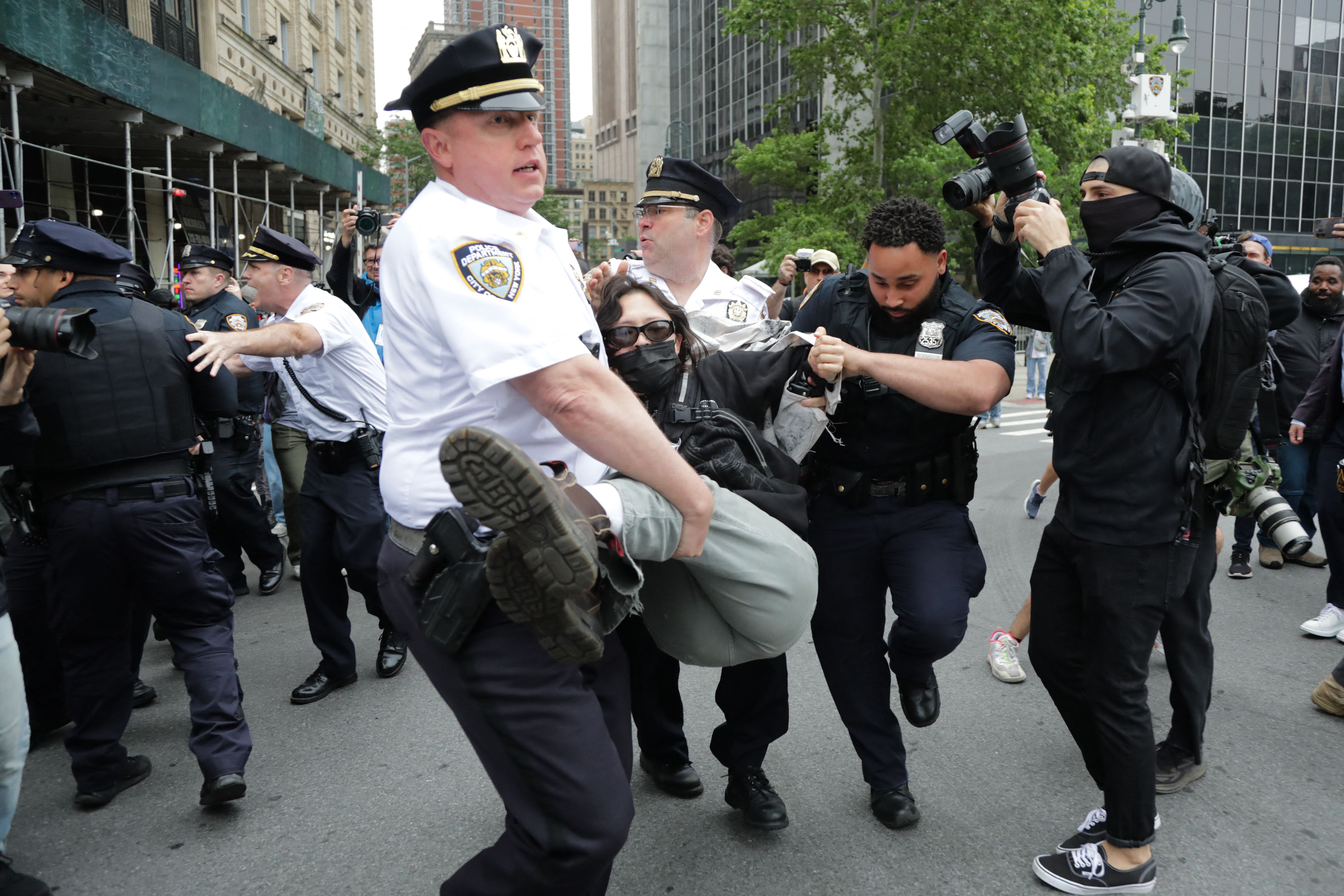 A protester is carried away by police in New York while someone tries to take a photo.