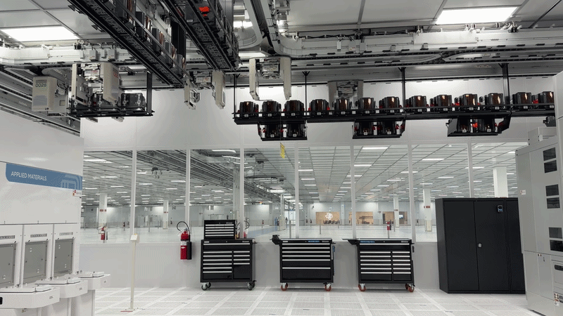 A GIF of an overhead track moving parts around in a lab-like room